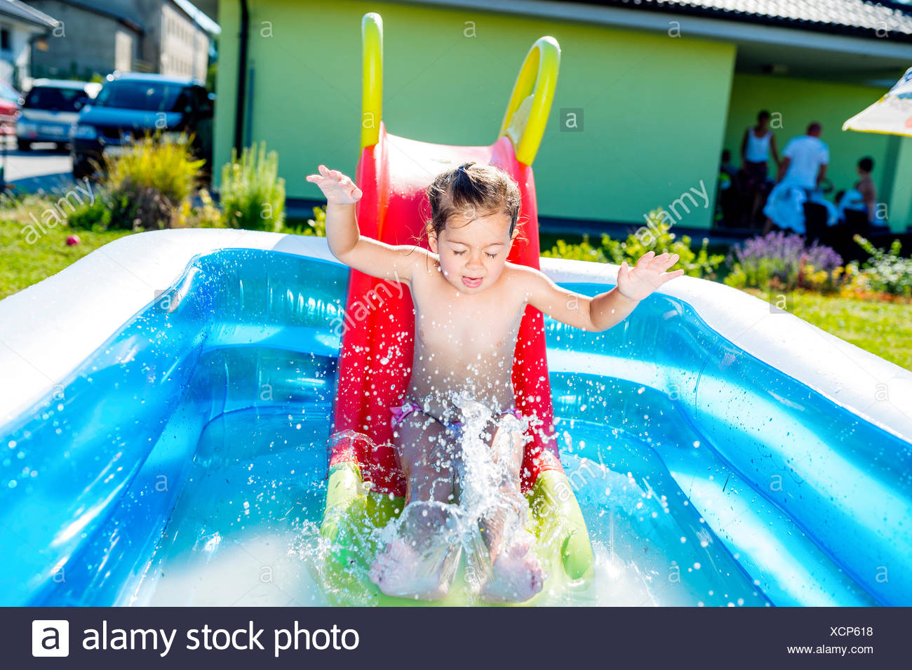 Little boy sliding into paddling pool 