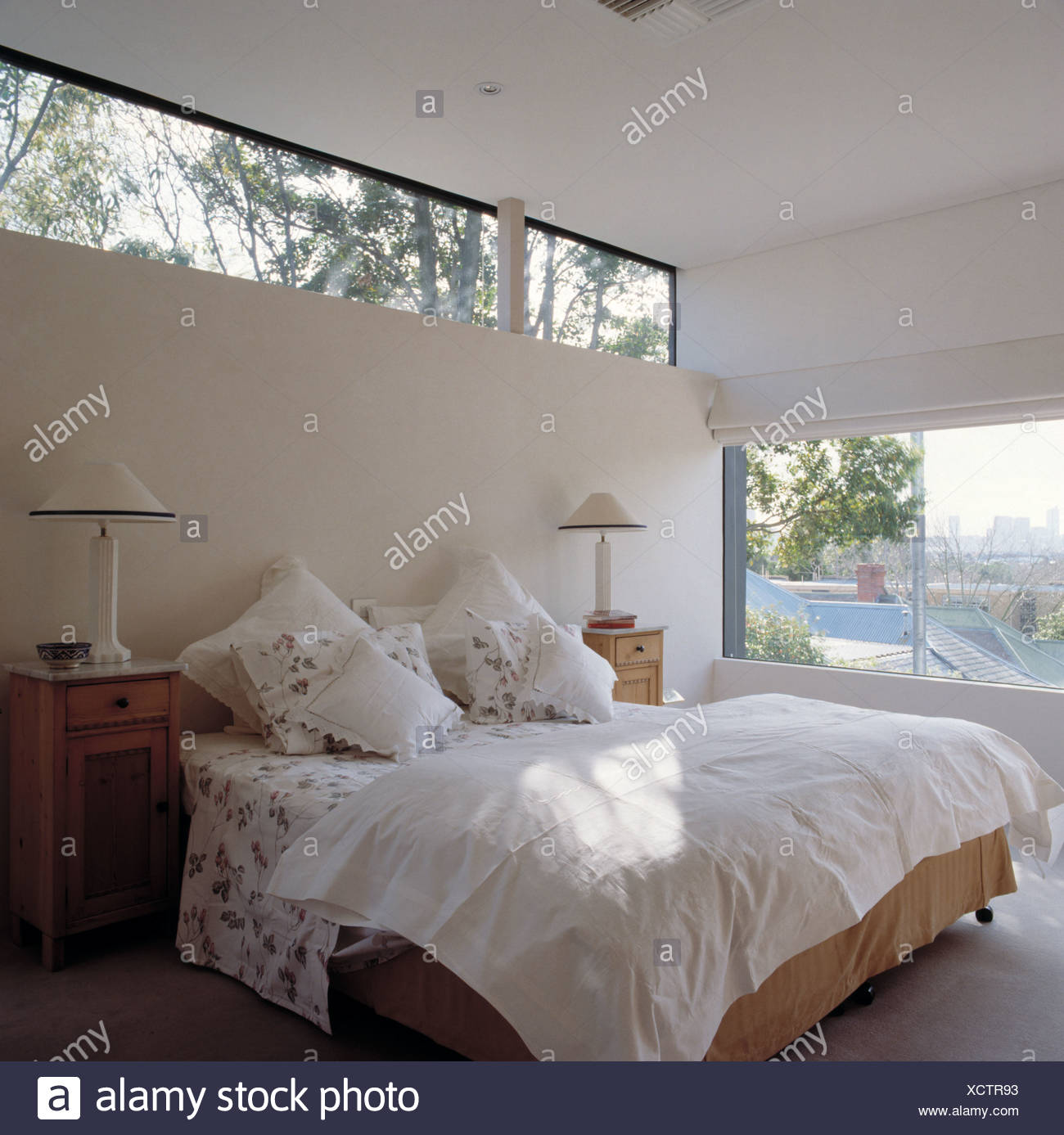 Narrow window above bed with white pillows and quilt in Narrow window above bed with white pillows and quilt in