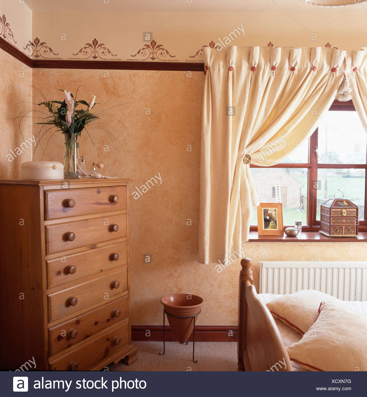 Chest Of Drawers In Corner Of Small Bedroom With Cream Curtains At