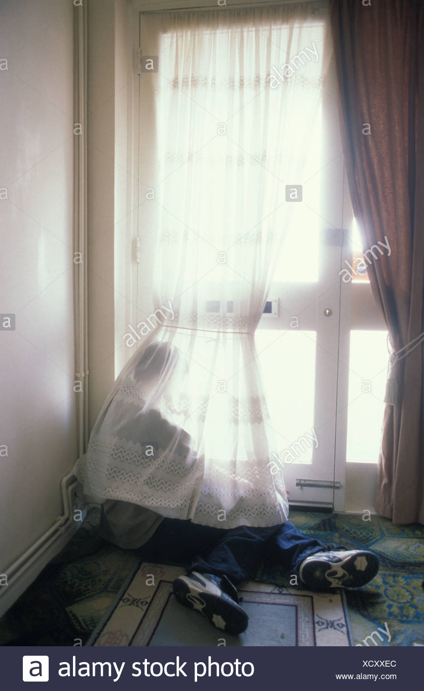Young Victim Of Child Abuse Boy Sitting On Floor Hidden By Net