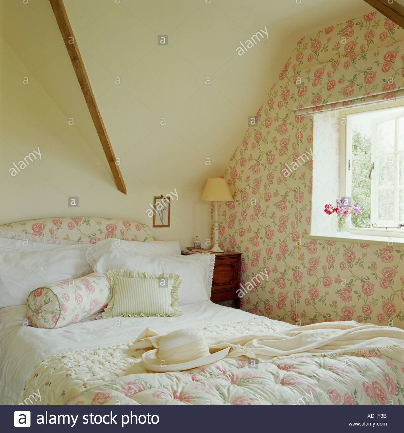 Rose Patterned Quilt And Cushion On Bed In Attic Bedroom