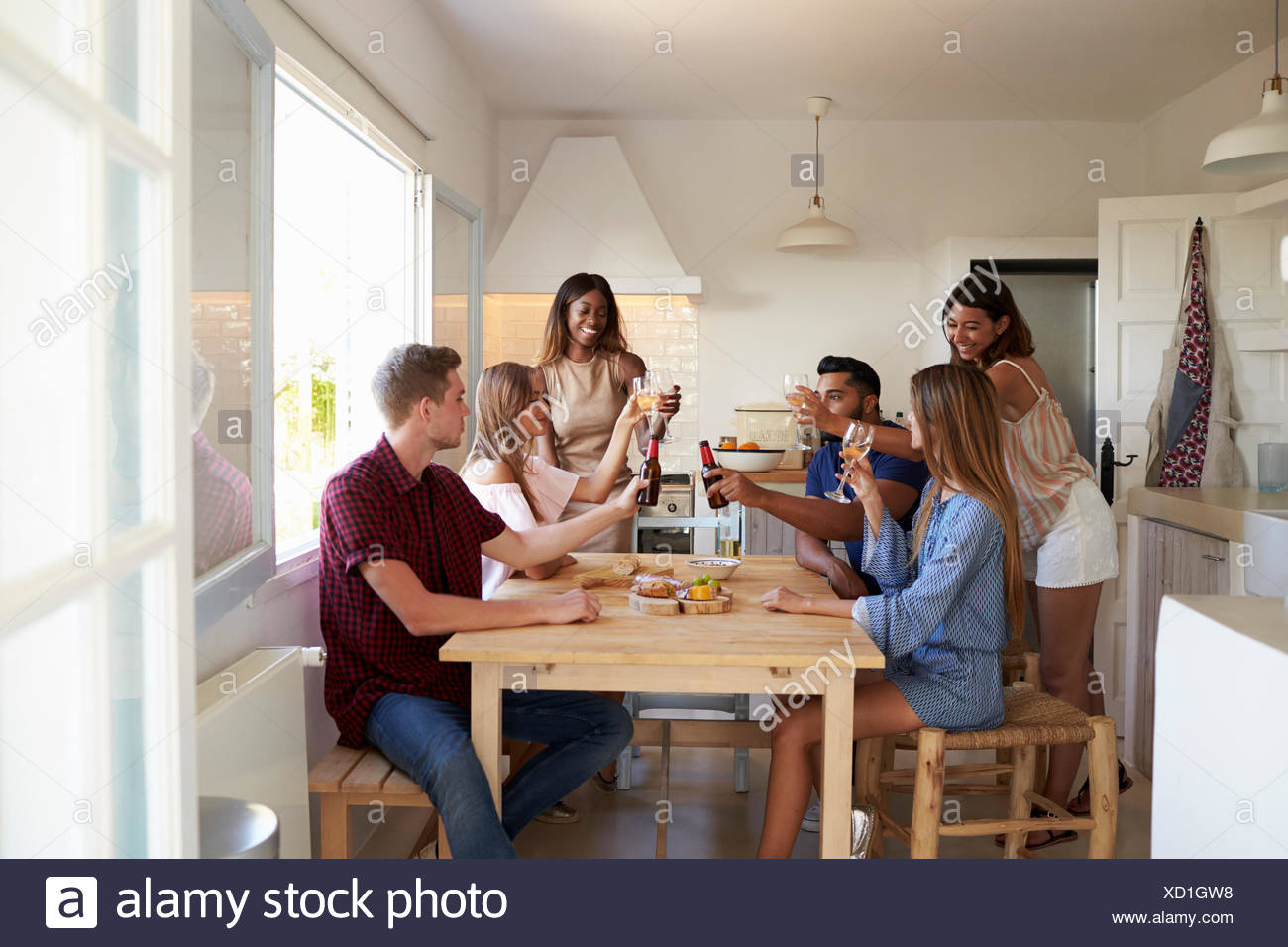 Six adult friends at a casual dinner party making a toast Stock Photo -  Alamy