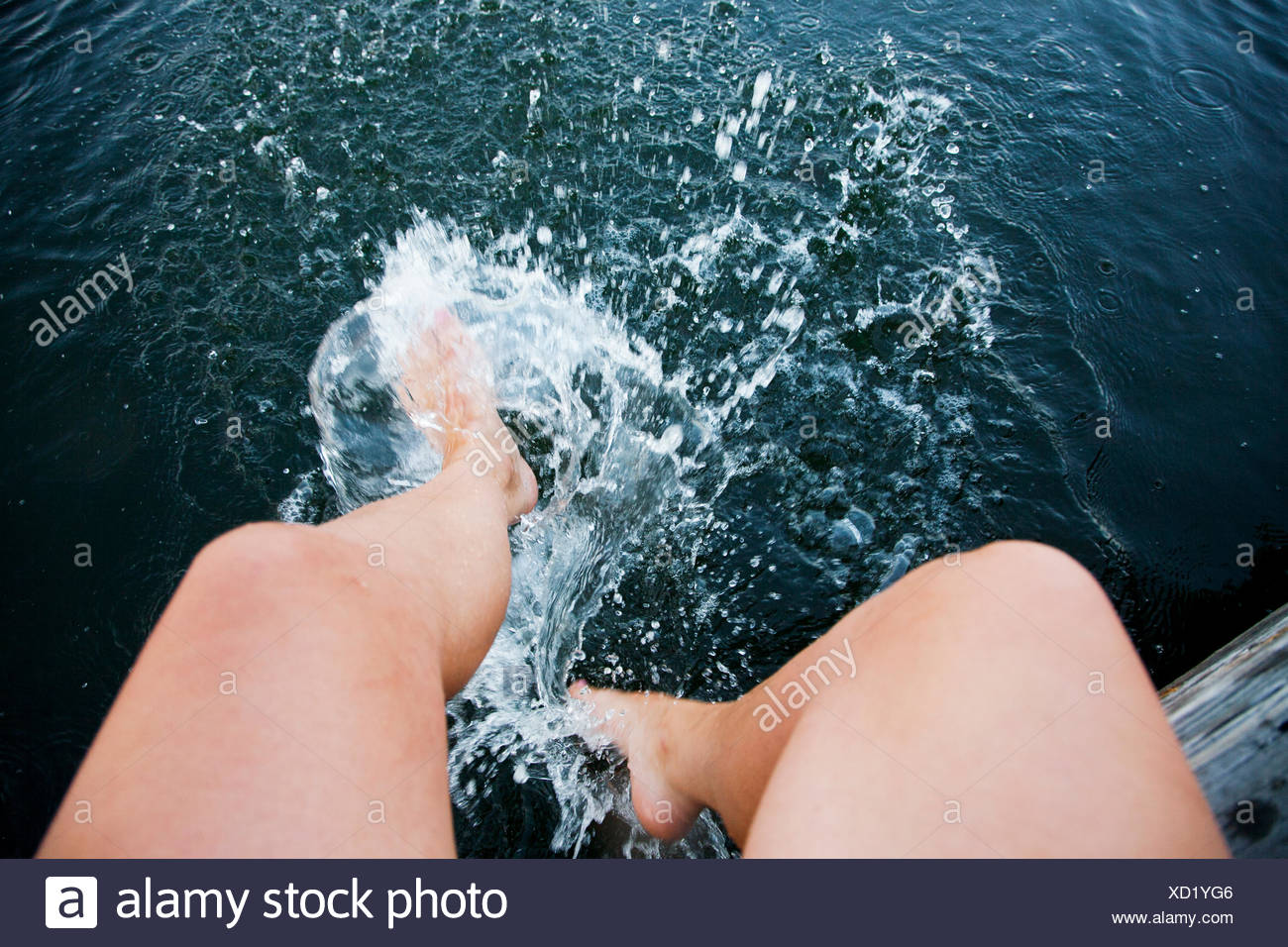Sweden, Uppland, Stockholm Archipelago, Woman splashing water with feet Stock Photo