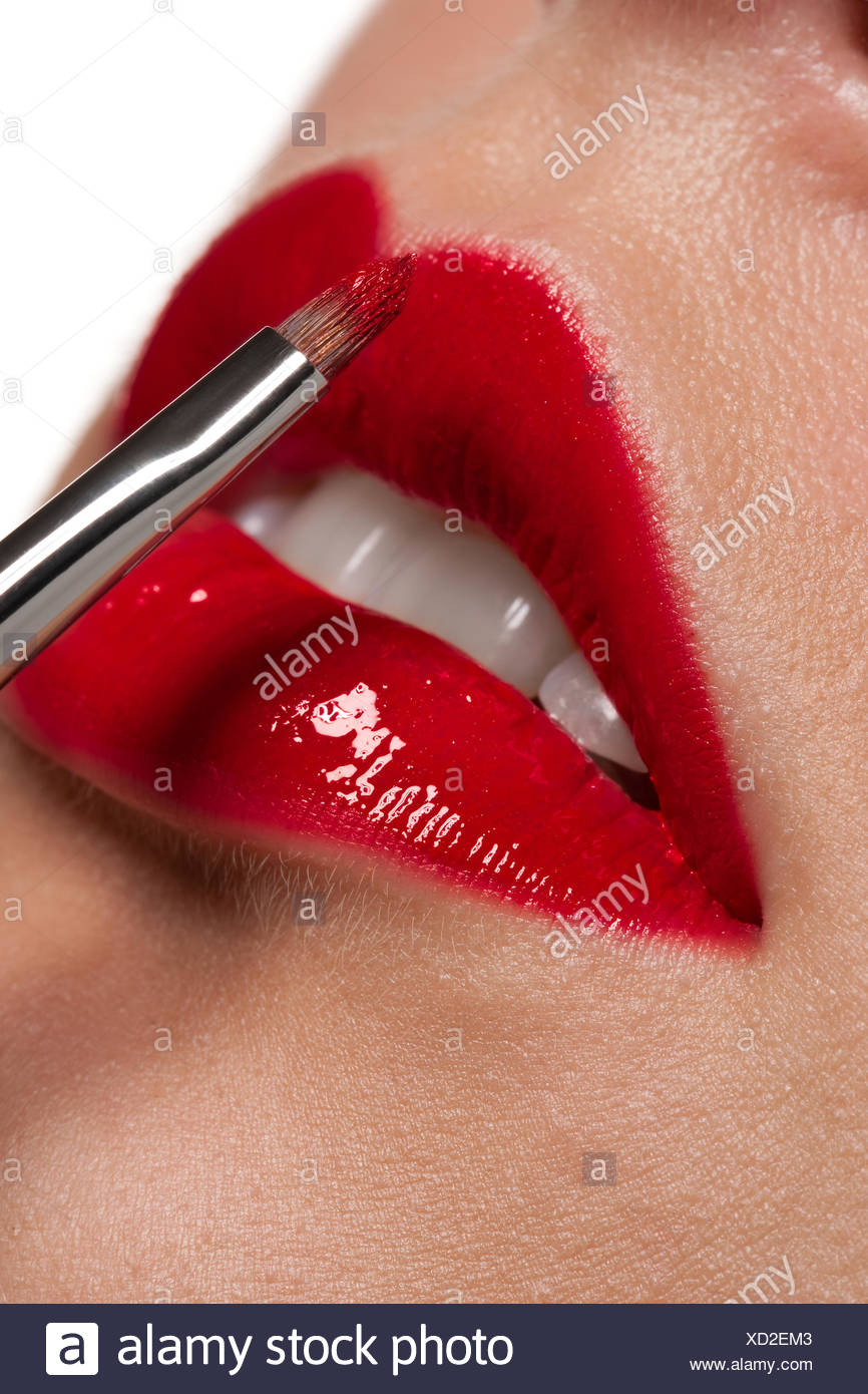 woman applying glossy red