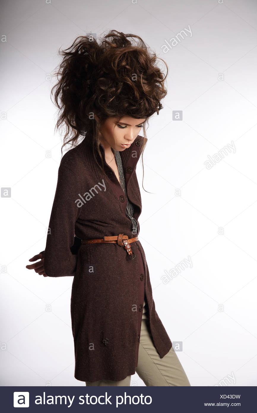Glamorous Woman In Brown Jacket Looking Down Stock Photo