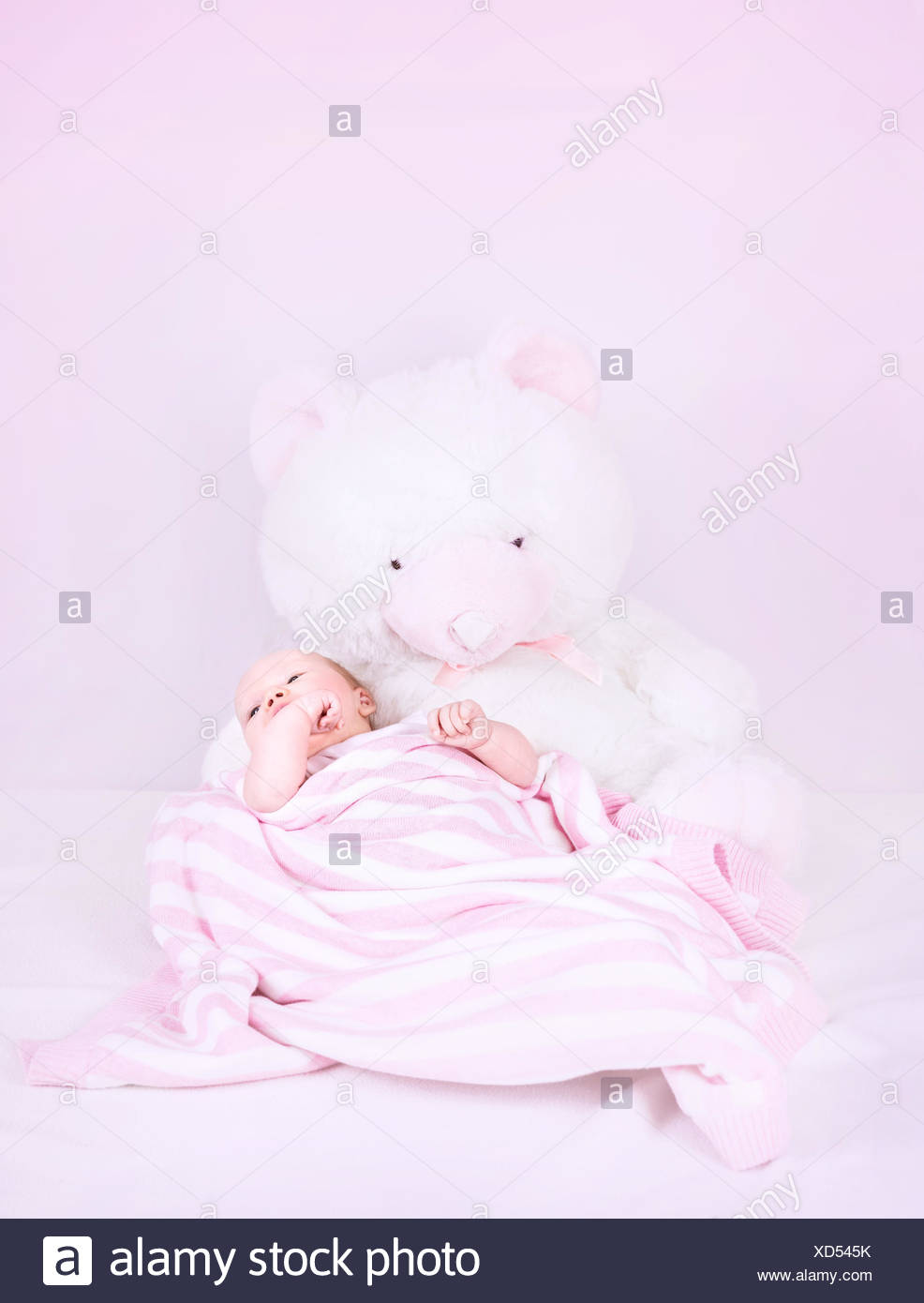 Cute Little Newborn Girl Lying Down On Big White Soft Bear