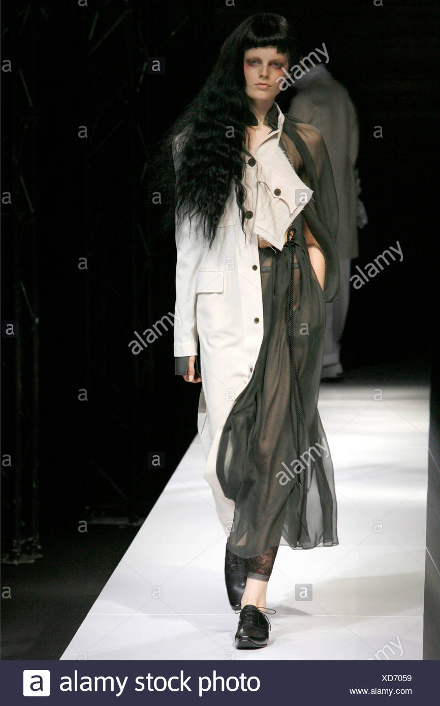 Female Model With Long Black Wavy Hair Wearing An Outfit One Side