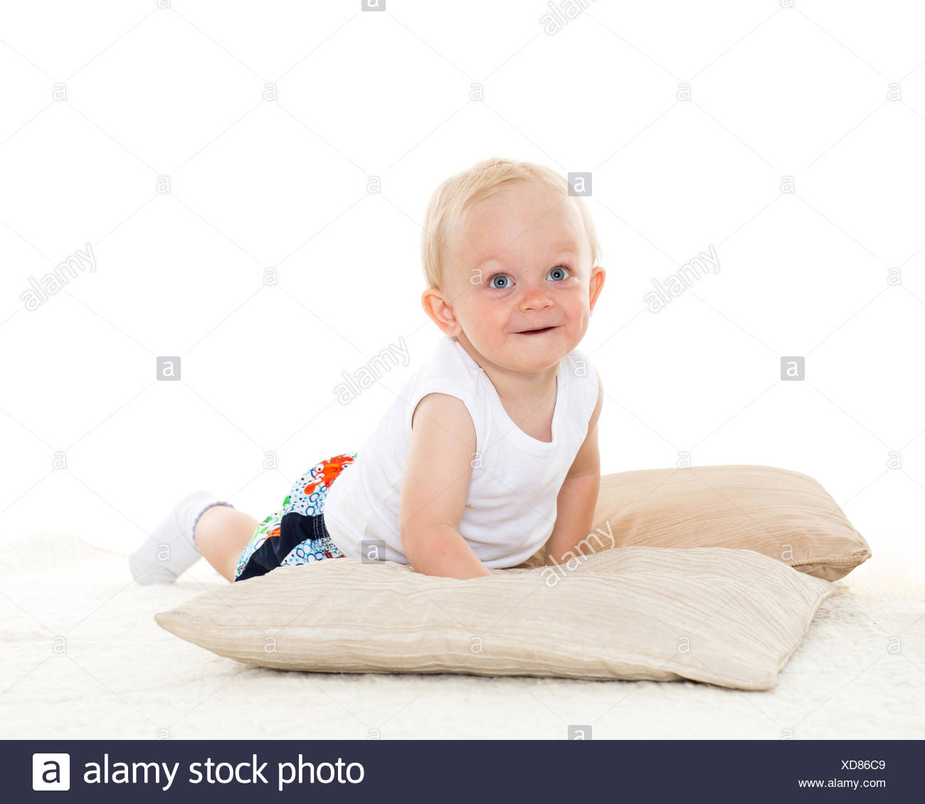 Sweet Small Baby Is Playing With Pillows On A White Background