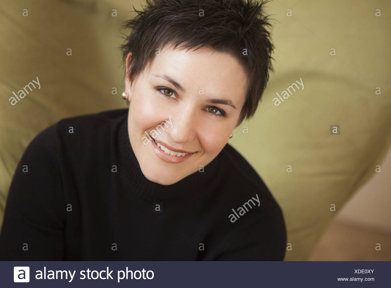 A Woman With Short Spiky Brown Hair Wearing A Black Turtleneck