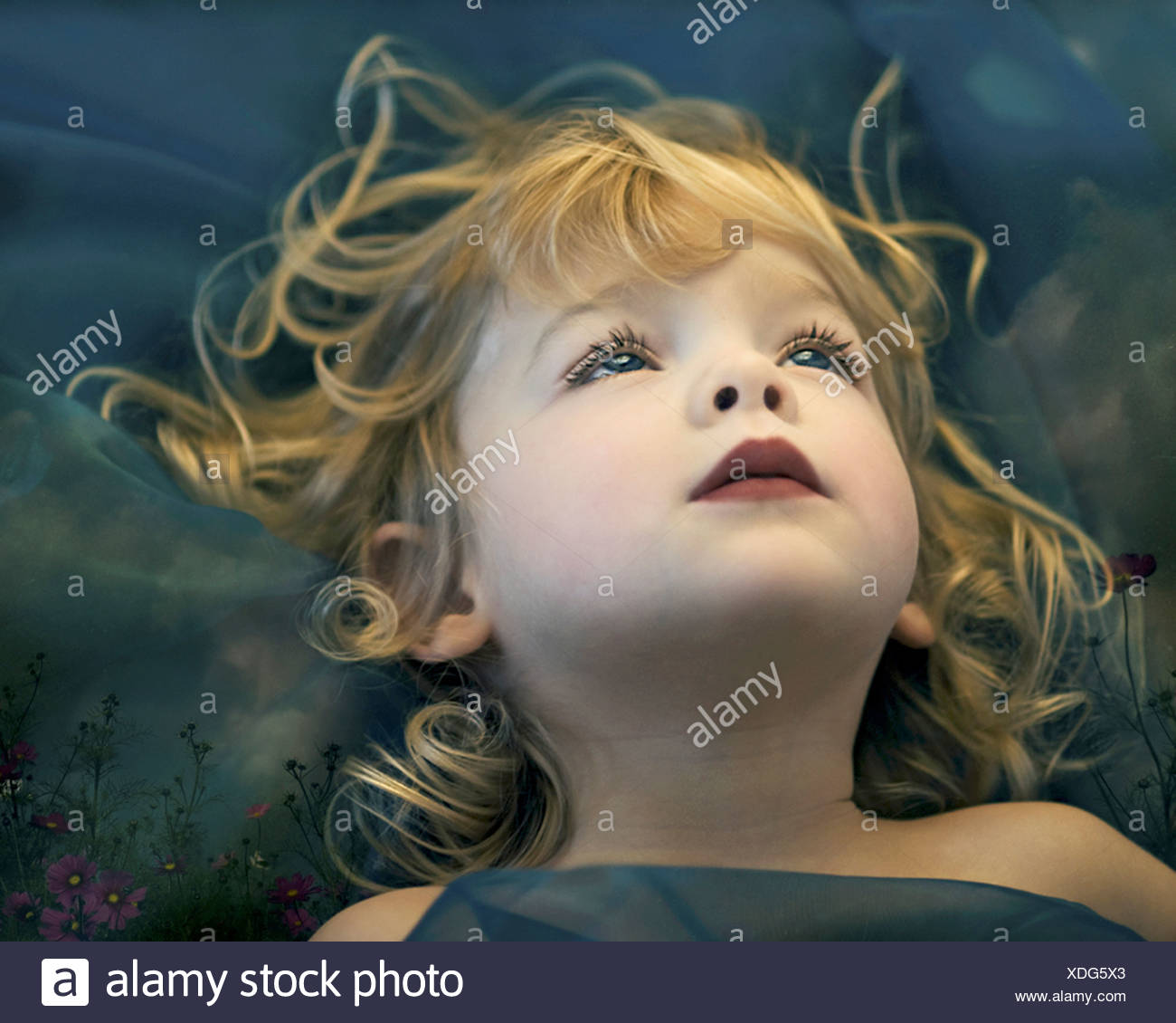 A Young Girl With Long Blonde Wavy Hair Staring Into The Blue