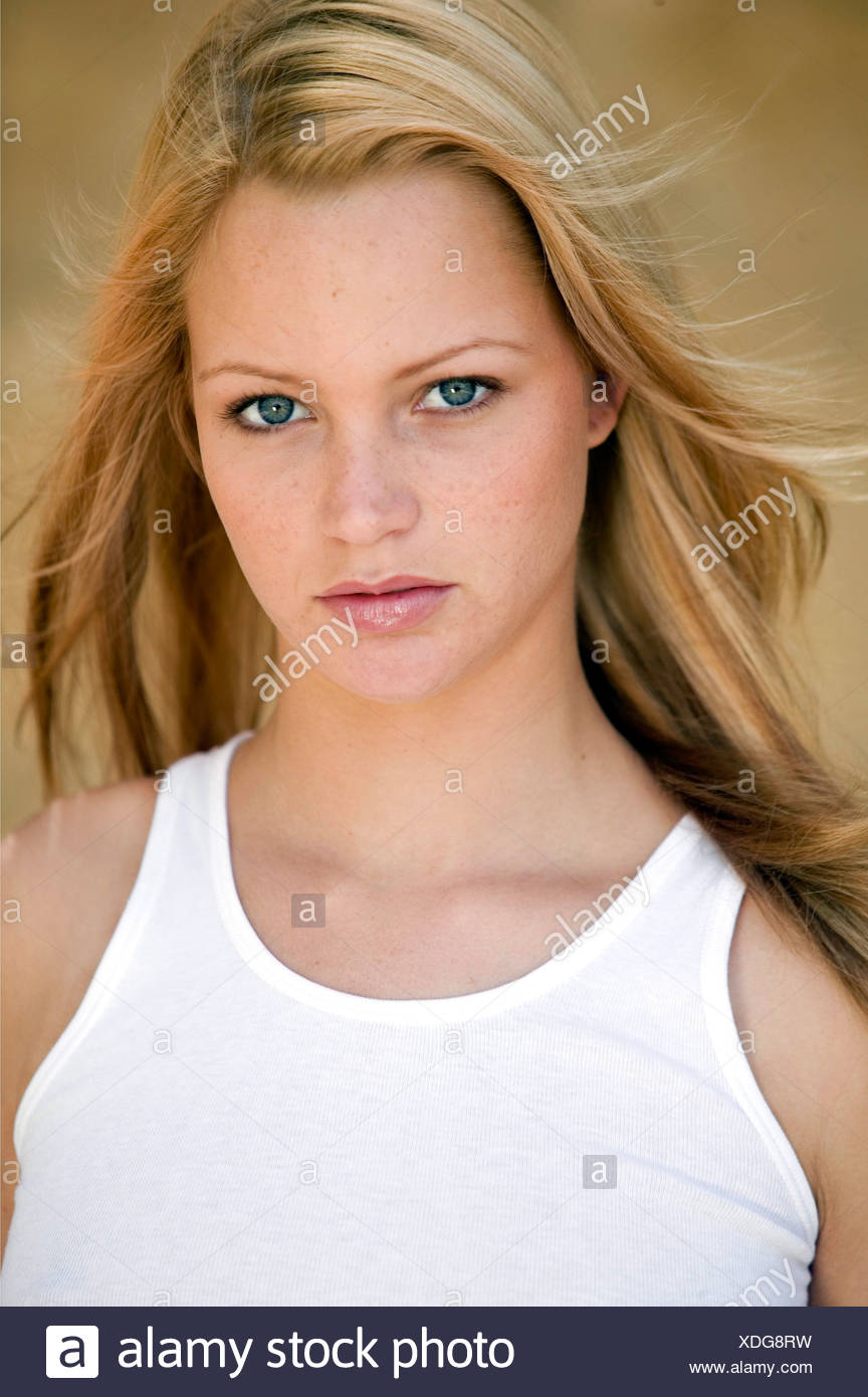 Female Long Straight Blonde Hair And Blue Eyes Wearing A White Vest Top And Natural Make Up Her Hair Is Being Blown By The Stock Photo Alamy