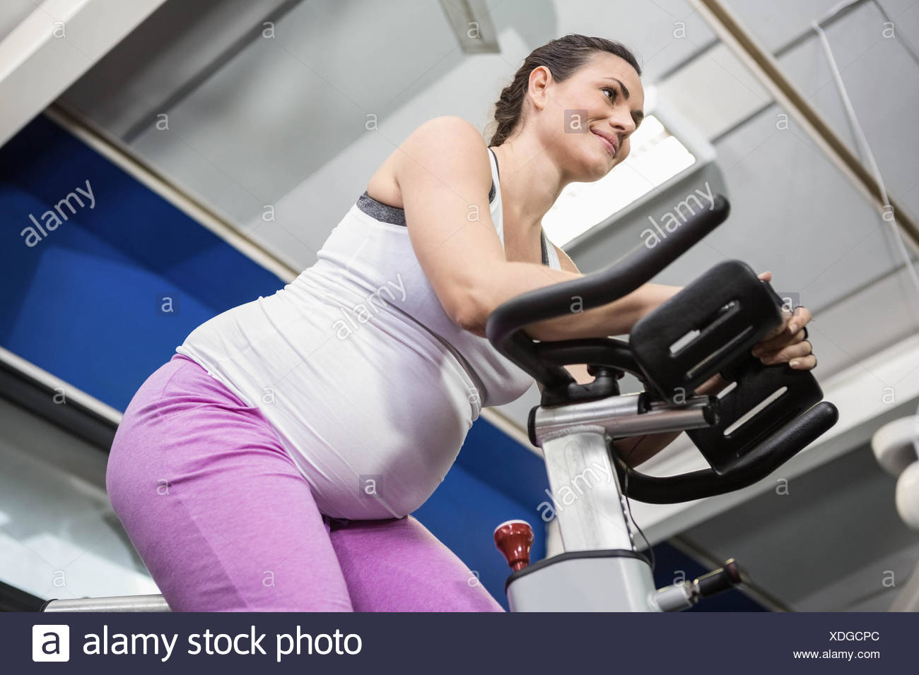 Woman Pregnant Riding Bike Side Stock Photos & Woman Pregnant Riding