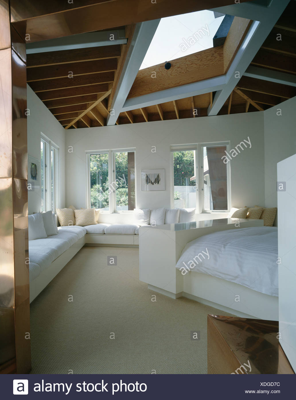 White Banquette Seating Below Windows In Modern White Bedroom With