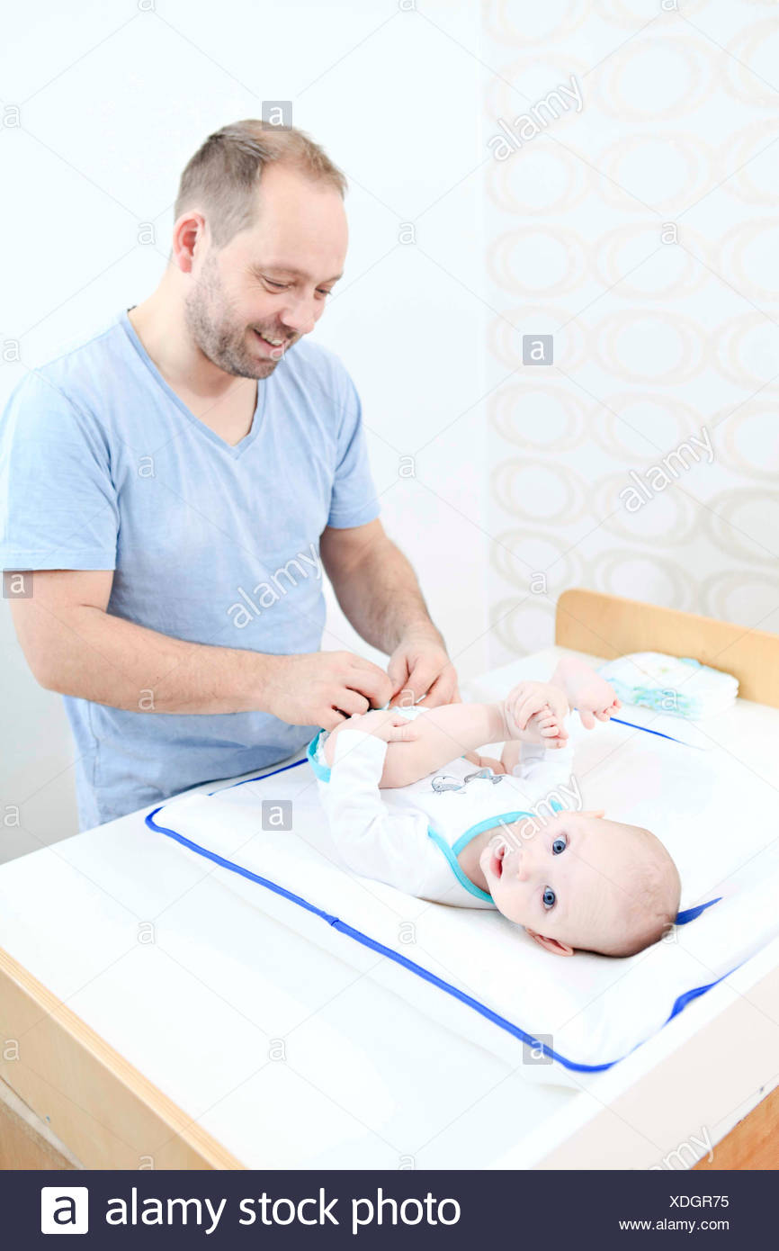 dad changing baby diapers