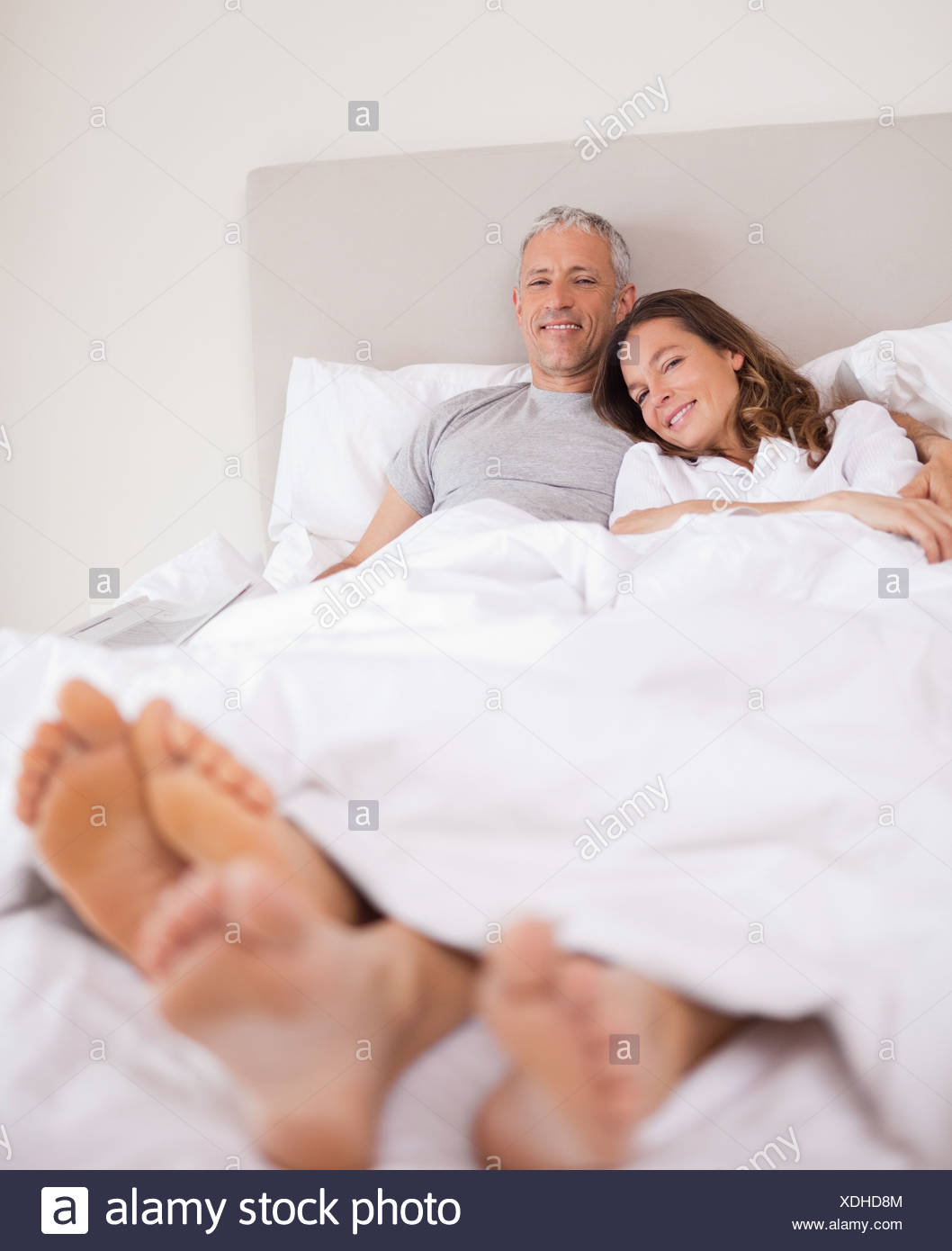 Portrait Of A Lovely Couple Lying On Their Bed Stock Photo