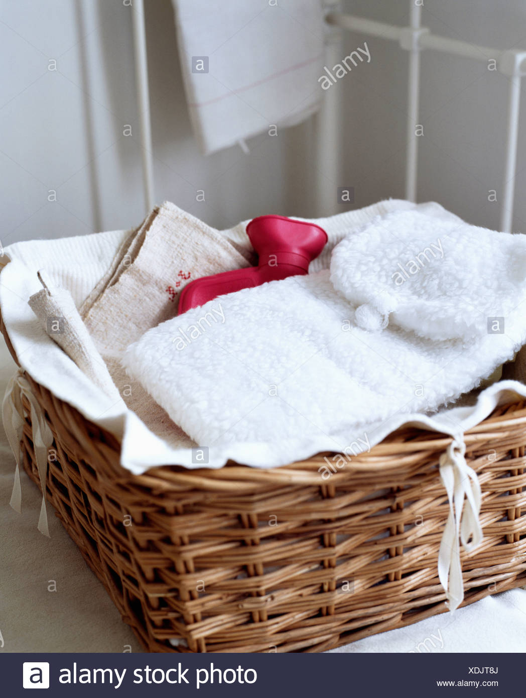 Close-up of wicker basket with white fleece hot-water bottle cover ...