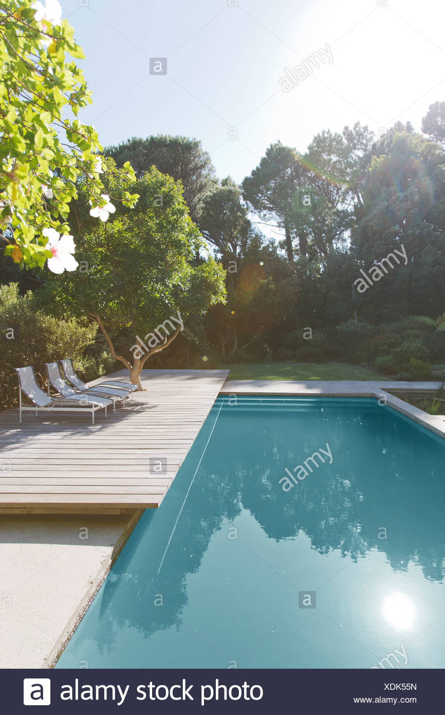 in pool lounge chairs on Wooden Deck And Lounge Chairs By Swimming Pool Stock Photo Alamy