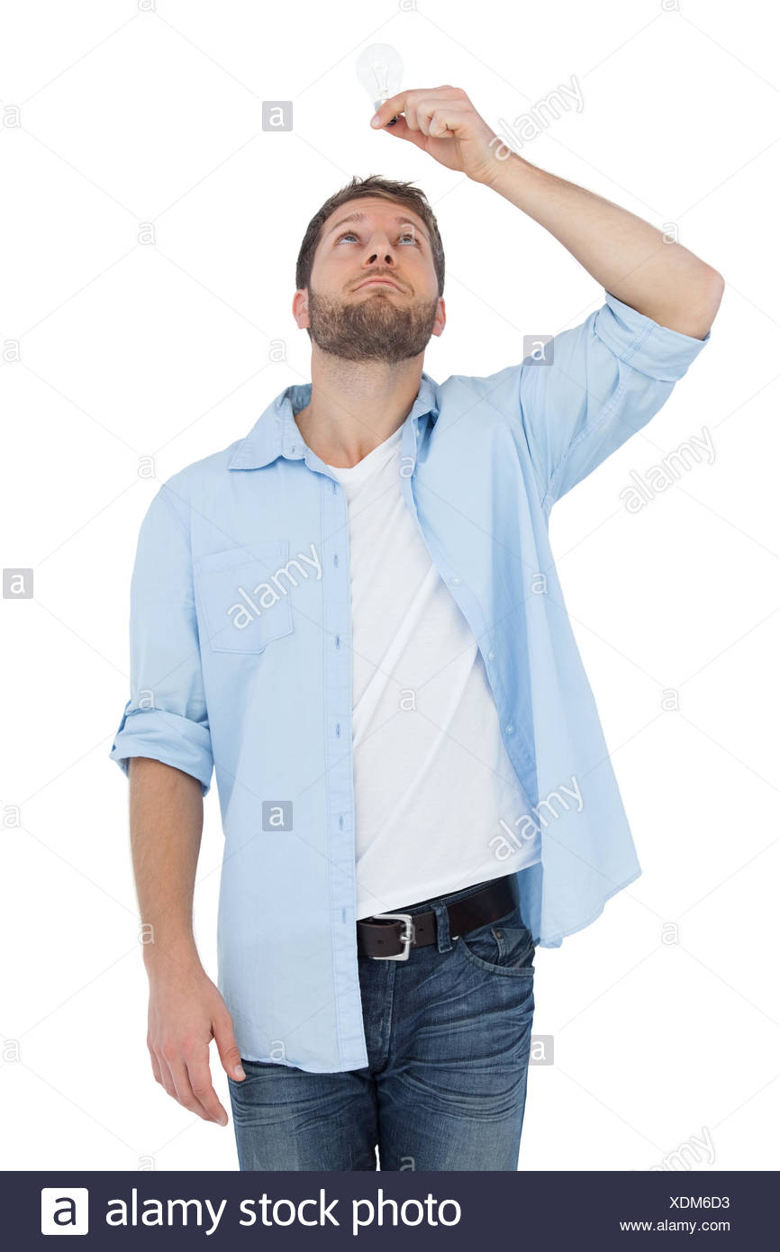 Sceptical Model On White Background Holding A Bulb Above His Head