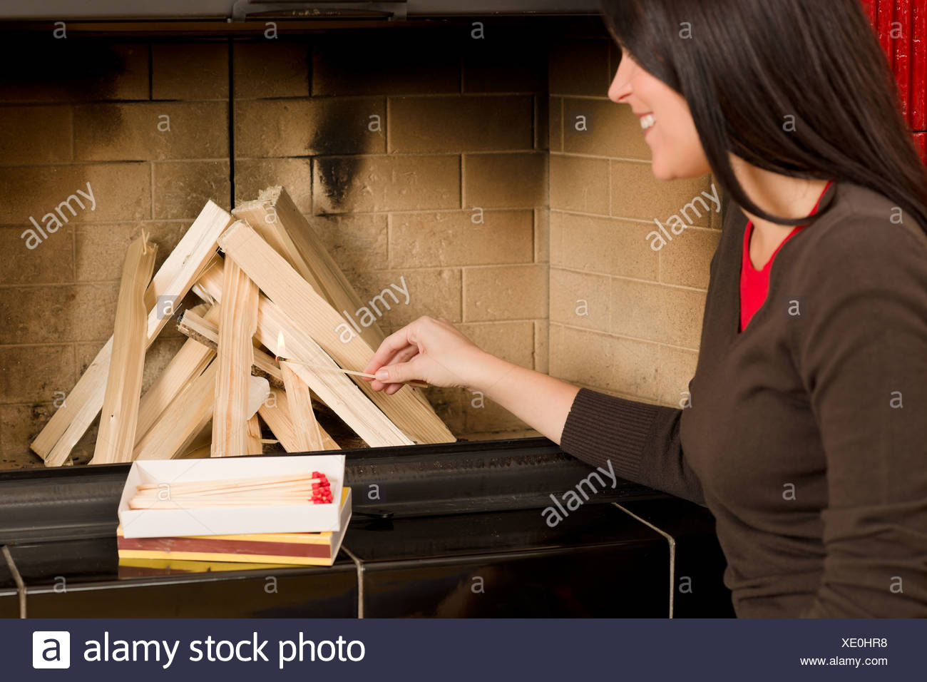 Home Fireplace Woman Lighting Up Wooden Logs Stock Photo