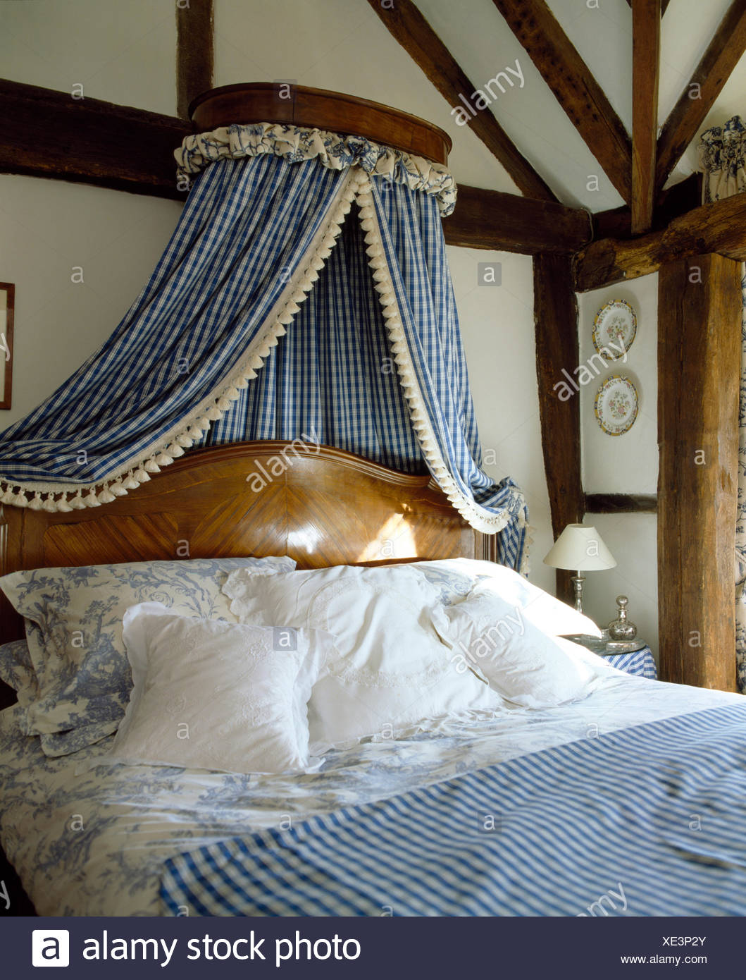 Coronet With Checked Drapes Above Antique Bed With White Cushions