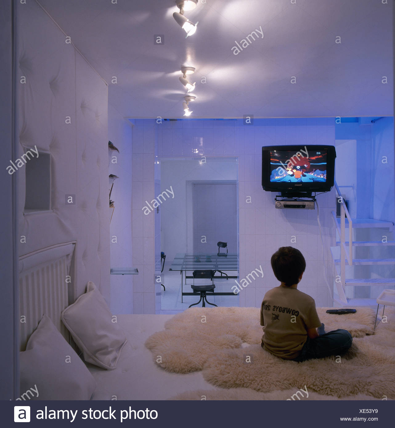 Small Boy Watching Television In Parents Modern Bedroom