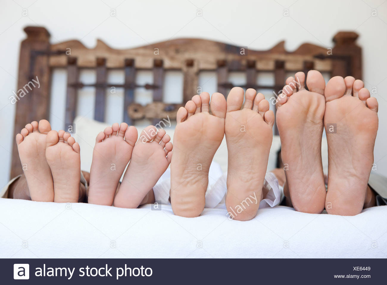 Family Lying On Bed Feet Lined Up Stock Photo Alamy