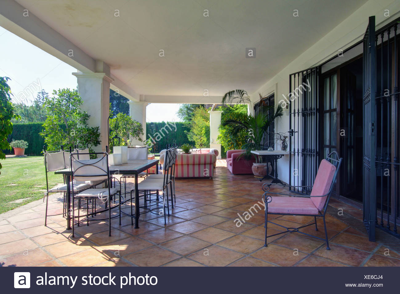 Metal Chairs And Table On Spacious Terracotta Tiled Veranda Of