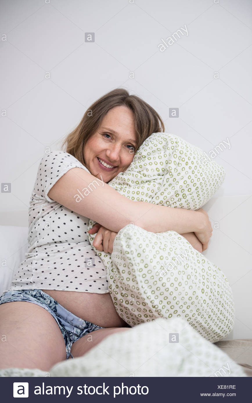 Happy Pregnant Woman Cuddling Her Pillow In Bed Munich Bavaria
