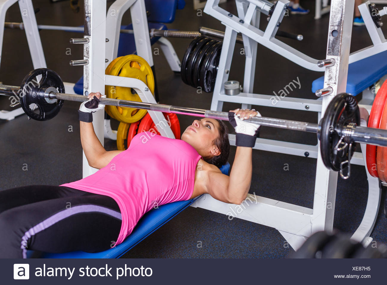Sports Young Woman Doing Exercises With Barbell On Bench In The