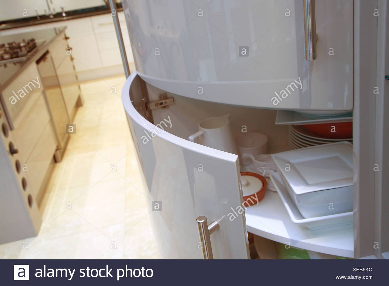 Close Up Of Curved Kitchen Cupboard Door Open To Show Crockery On