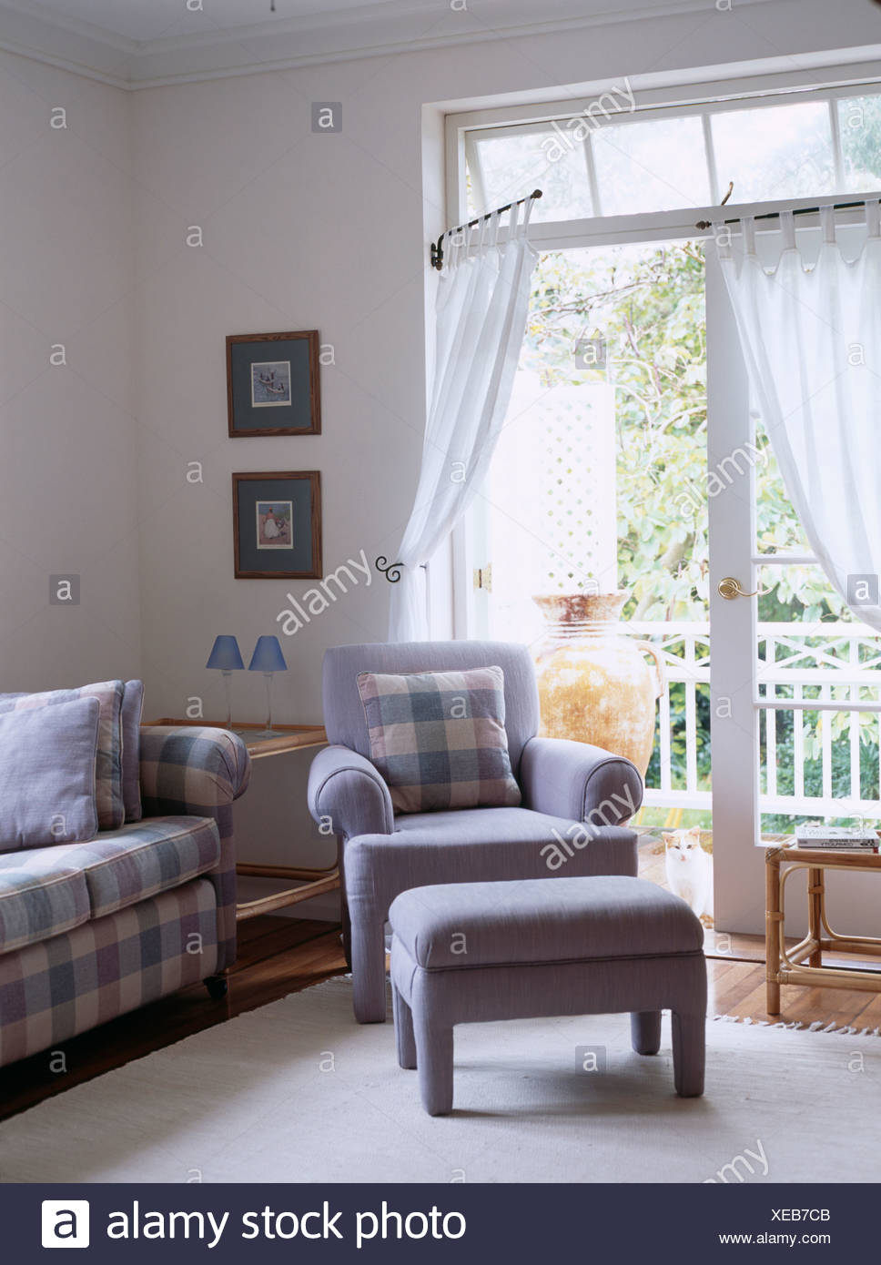 Blue Armchair And Footstool In Front Of French Windows With White