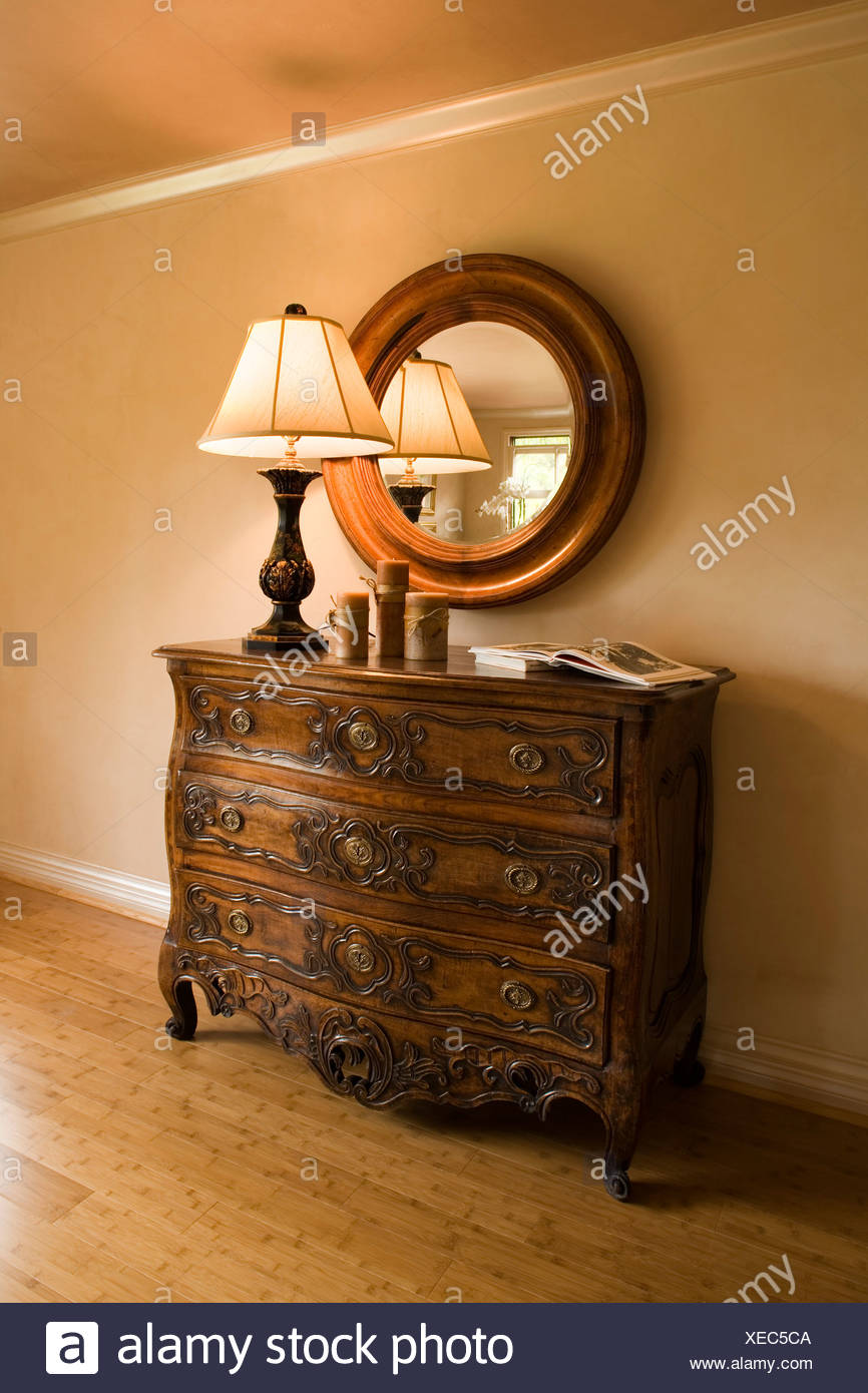 Ornate Wood Dresser With Lamp And Round Mirror Stock Photo
