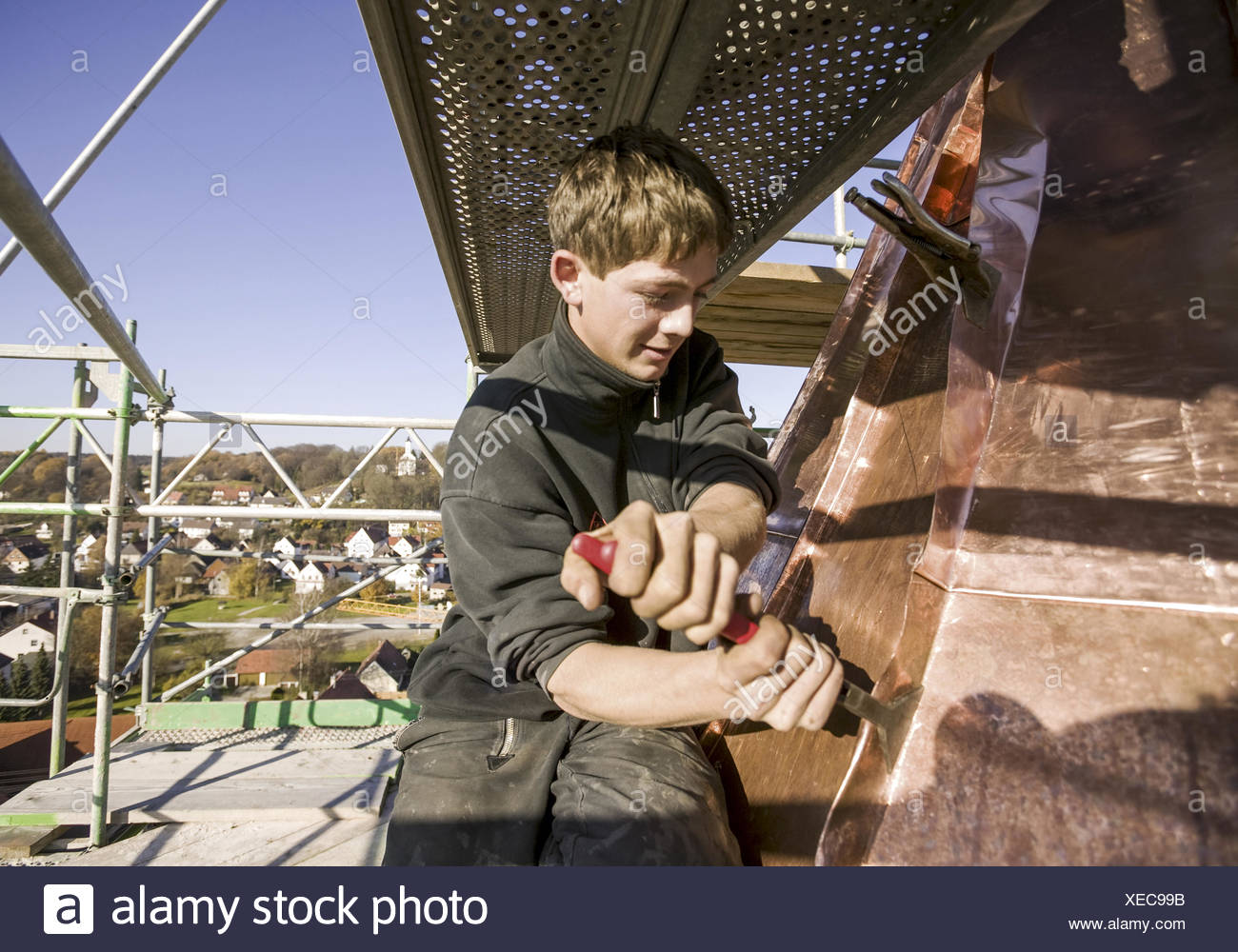 Spengler, Lehrling arbeitet mit Stemmeisen an Kupferdach eines Kirchturms (model-released) Stock Photo
