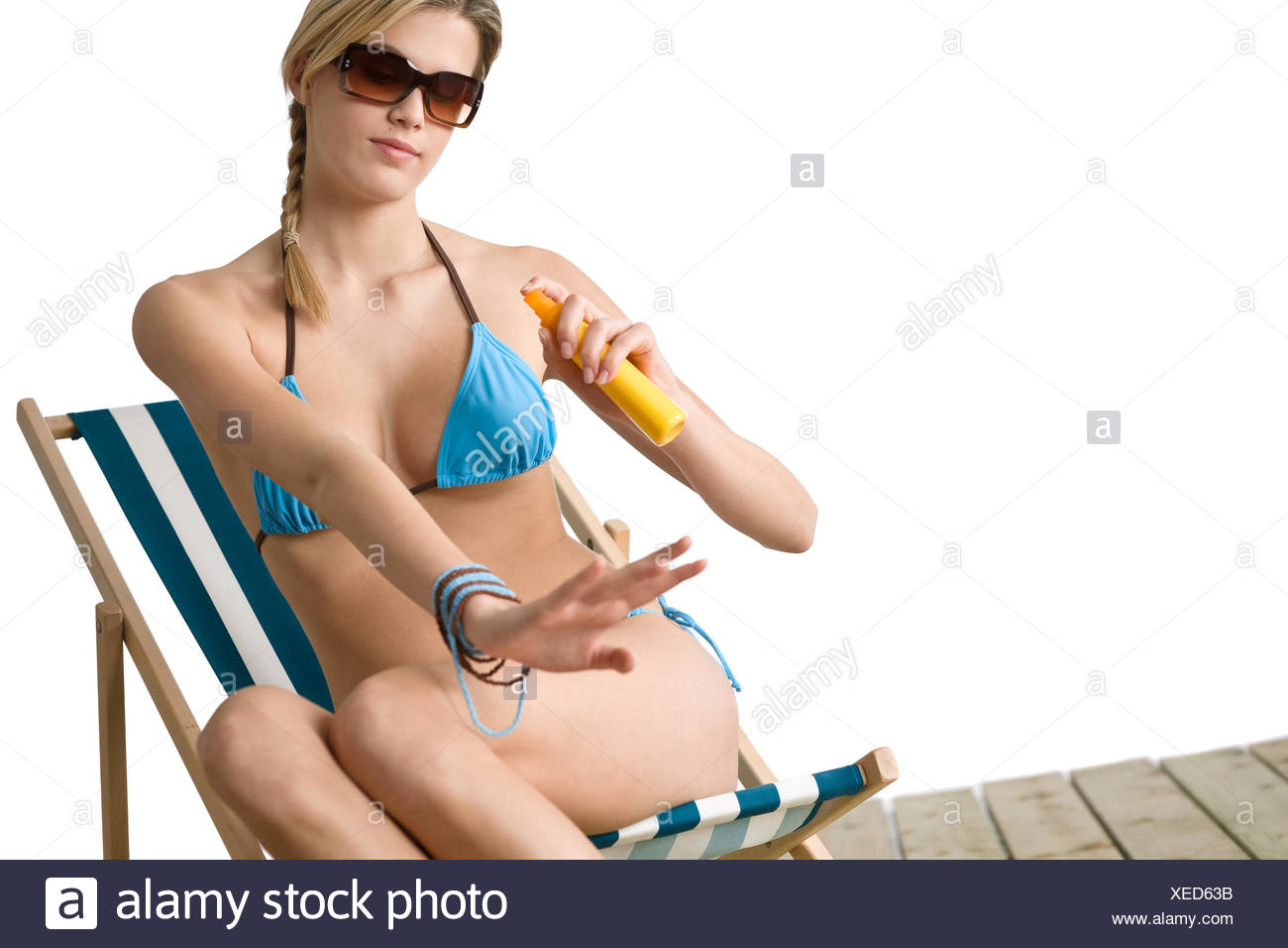 Beach - Young woman in bikini apply suntan lotion Stock Photo - Alamy