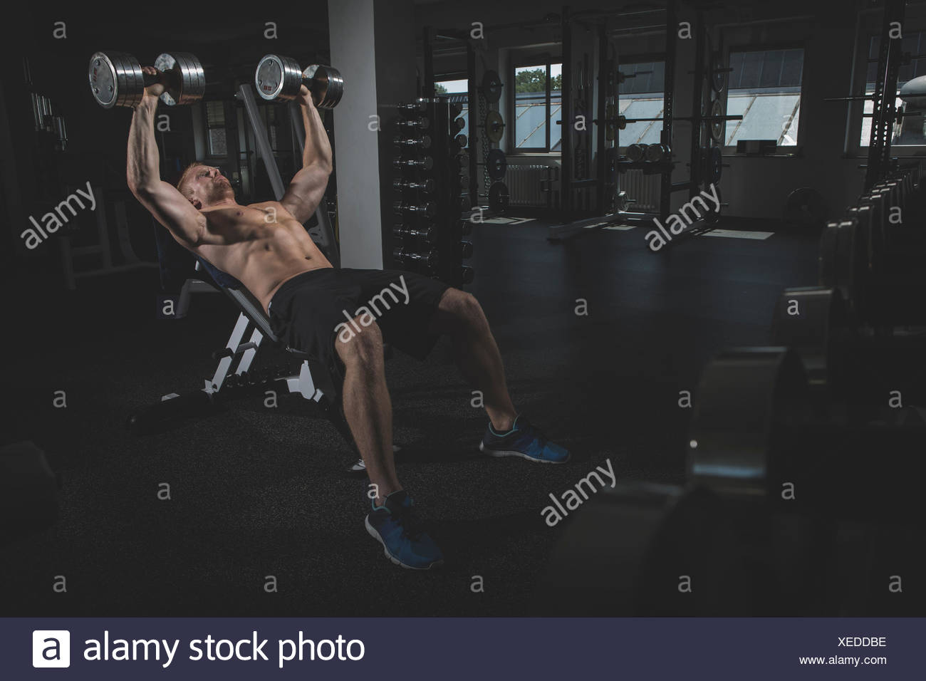 Physical Athlete Doing Bench Presses With Dumbbells Stock Photo