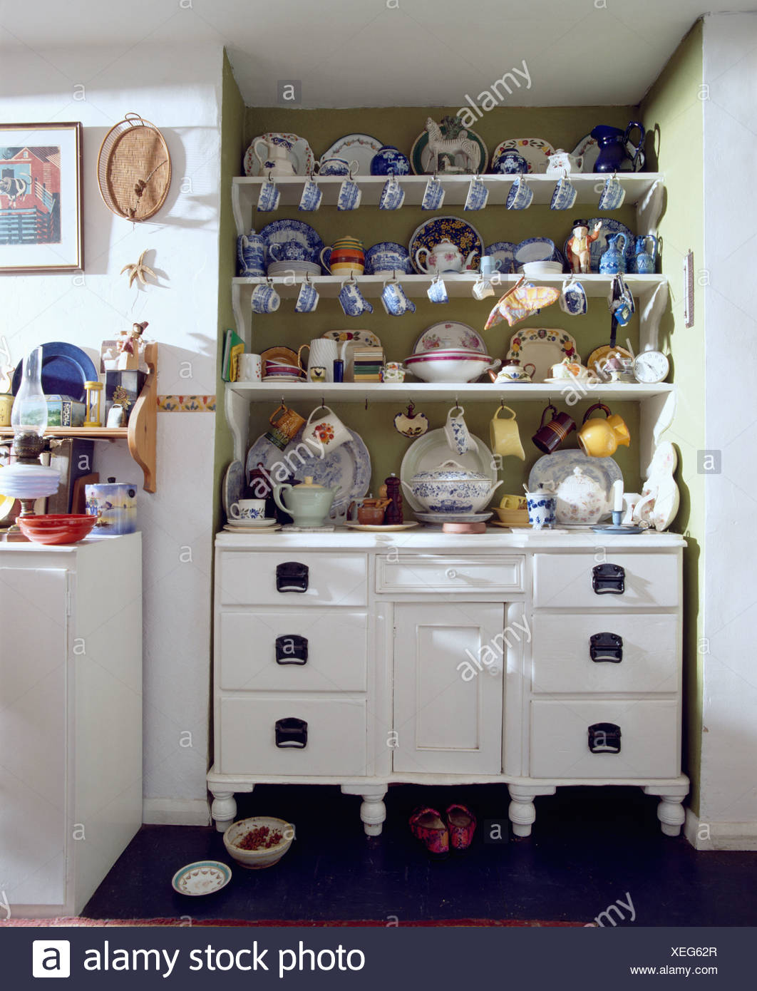 Cups And Plates On Painted White Dresser In White Cottage Kitchen