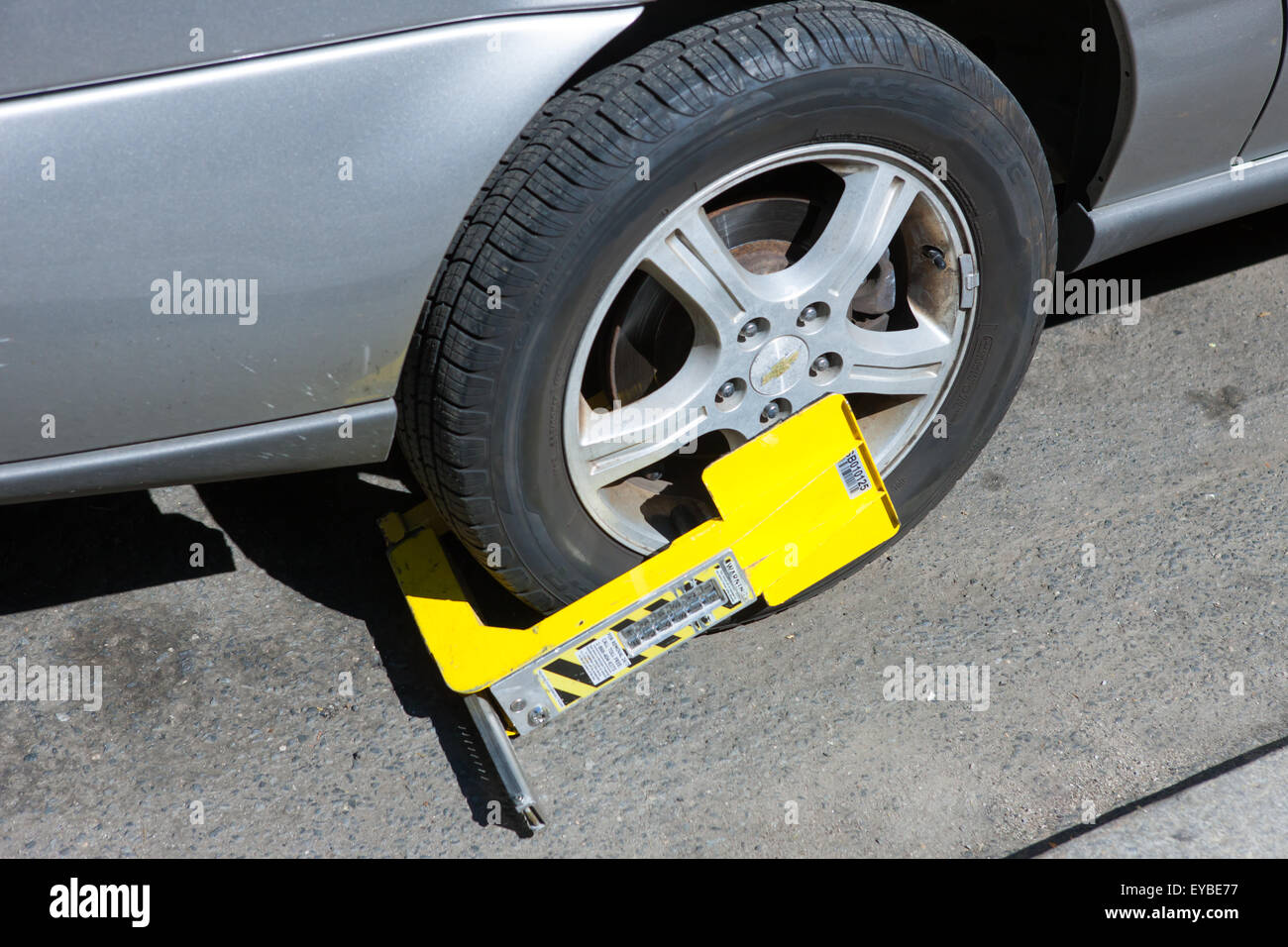 A Paylock tire boot immobilizes a car with outstanding parking