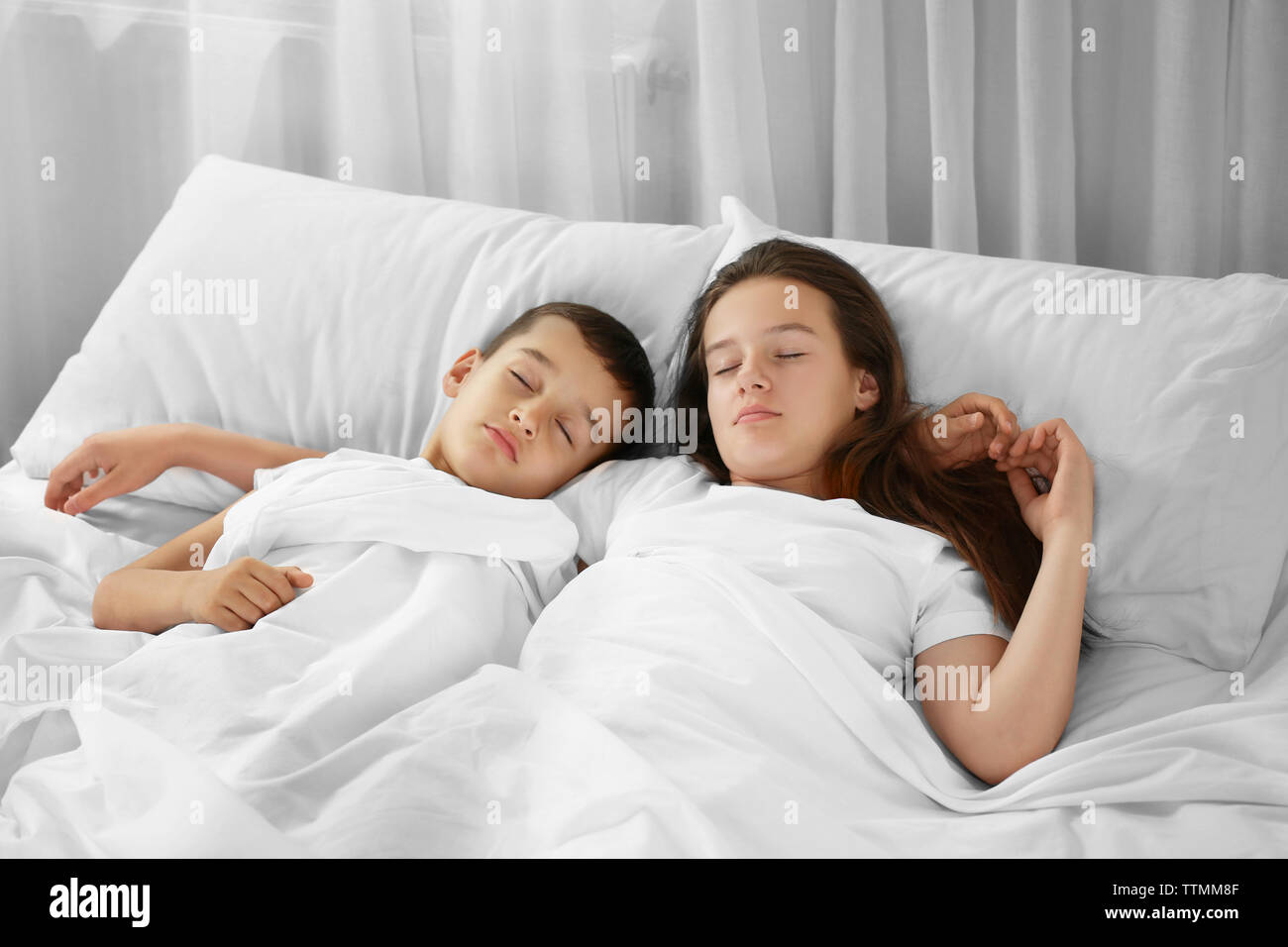 Brother and sister sleeping in bed Stock Photo - Alamy