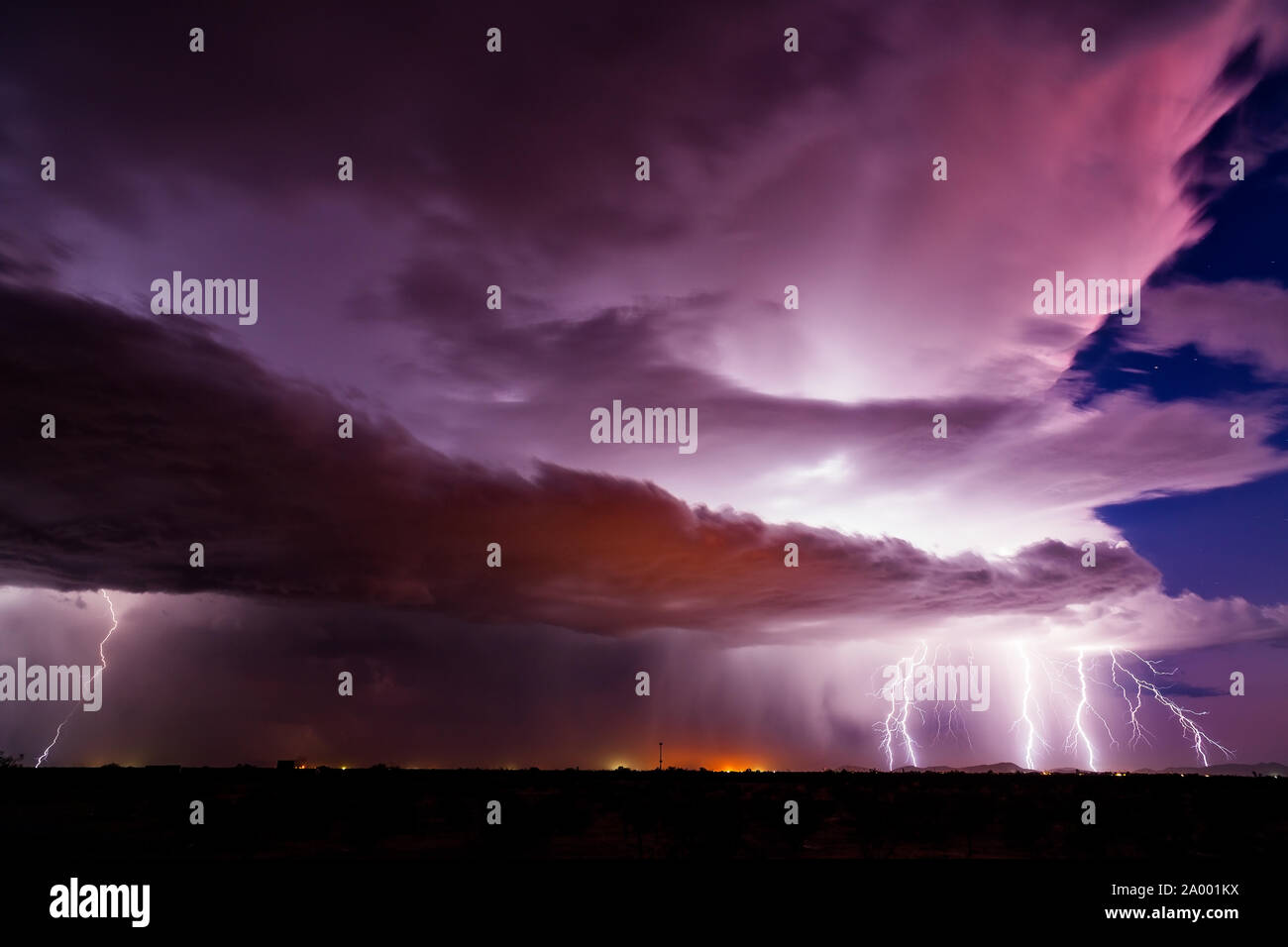 Dramatischer Sonnenuntergangshimmel mit Blitzen, die von einer Monsun-Gewitterwolke in der Wüste in der Nähe von Wintersburg, Arizona, getroffen wurden Stockfoto