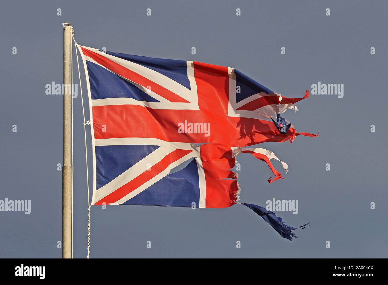 Britische Flagge oder Union Jack zerrissenen und zerfetzten Fliegen im Winter am Meer in Italien, die die Katastrophe von Brexit Stockfoto