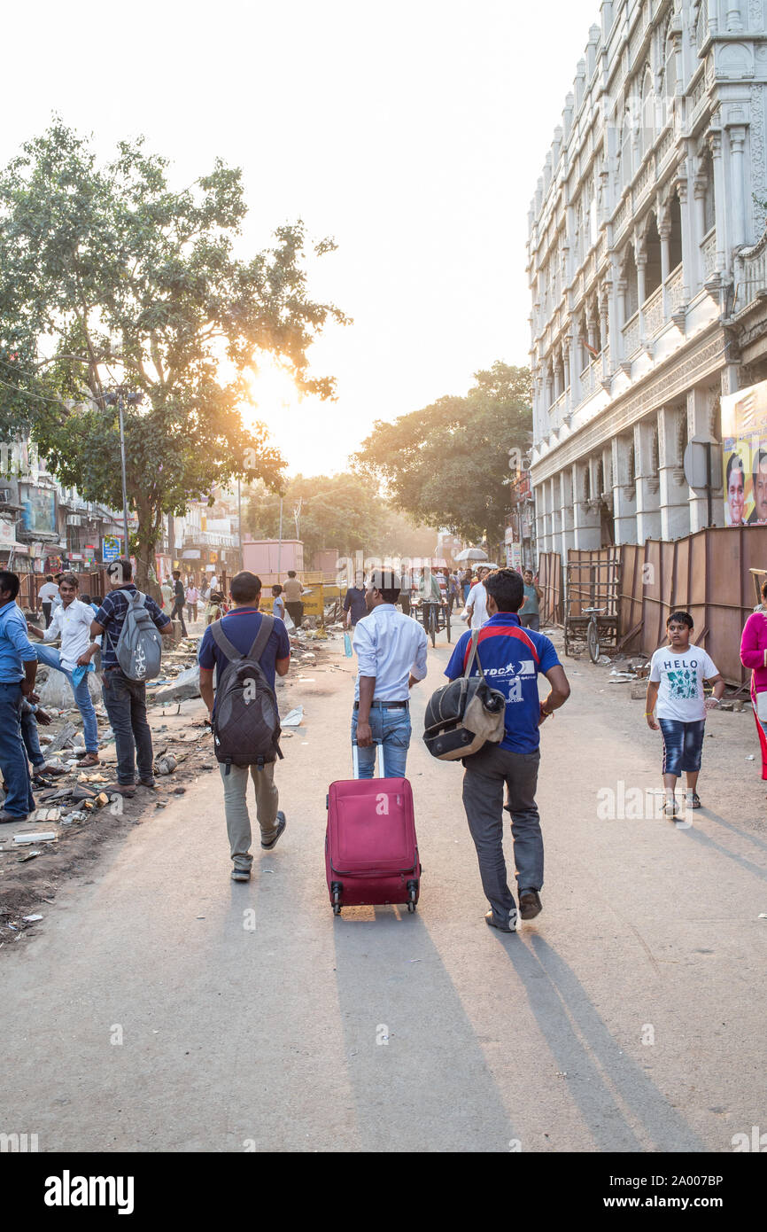 Die Reisenden zu Fuß die Straße runter in Neu Delhi, Indien, bei Sonnenuntergang Zeit Stockfoto