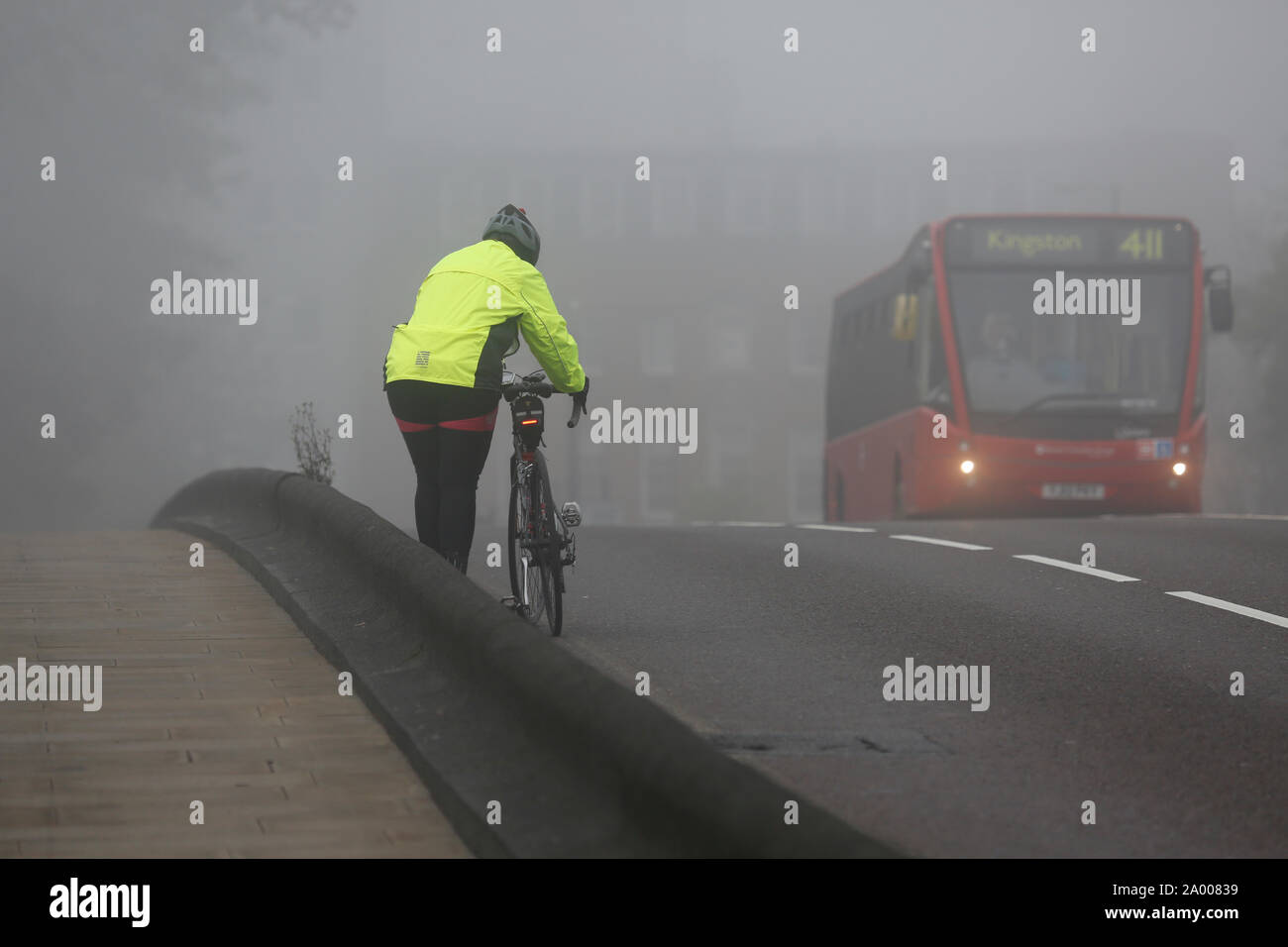 Radfahrer, Reiten, Fahrradverleih, Pendler, in dichtem Nebel, ein kalter Tag schlechtes Wetter. Stockfoto