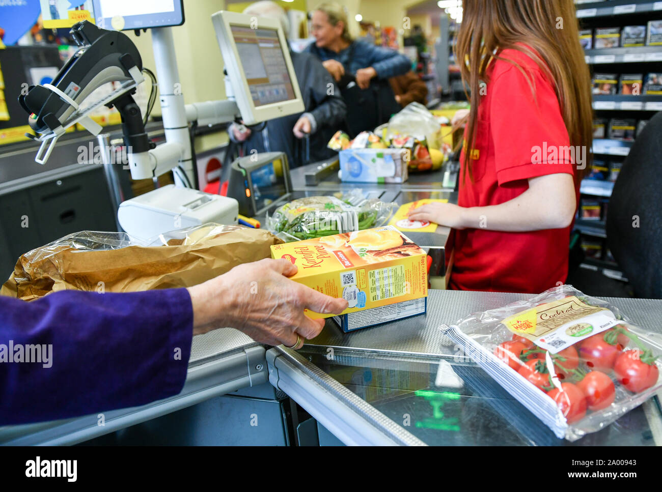 Berlin, Deutschland. 18 Sep, 2019. Der Kunde übernimmt die Ware vom Band an der Kasse nach einem Kassierer an der Kasse die Ware überprüft hat. Foto: Jens Kalaene/dpa-Zentralbild/ZB/dpa/Alamy leben Nachrichten Stockfoto