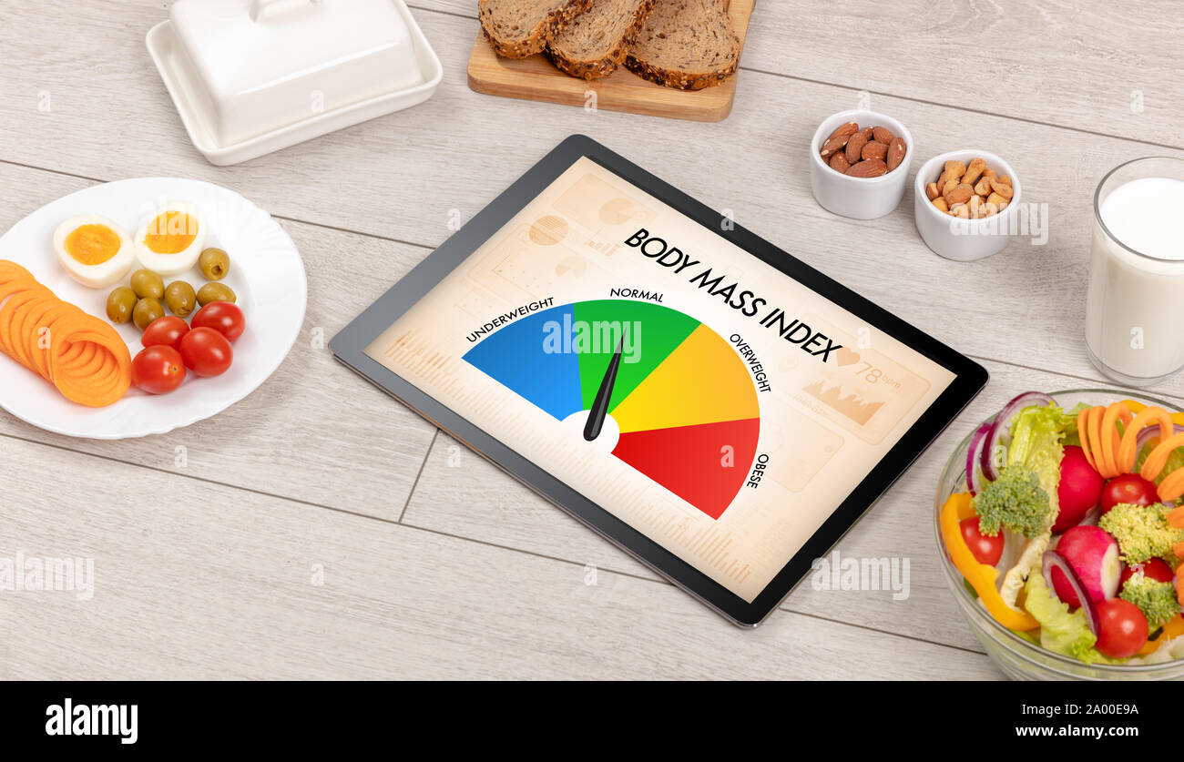 Gesund essen mit Tablet auf einem hölzernen Hintergrund mit Worten Body Mass Index. Gesundheit Konzept. Stockfoto