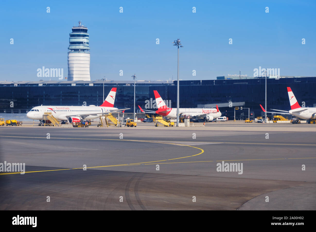 Schwechat, Österreich - 15. September 2019: Austrian Airlines Flugzeuge auf dem Boden am Flughafen Wien (VIE), mit Control Tower in der Rückseite Stockfoto