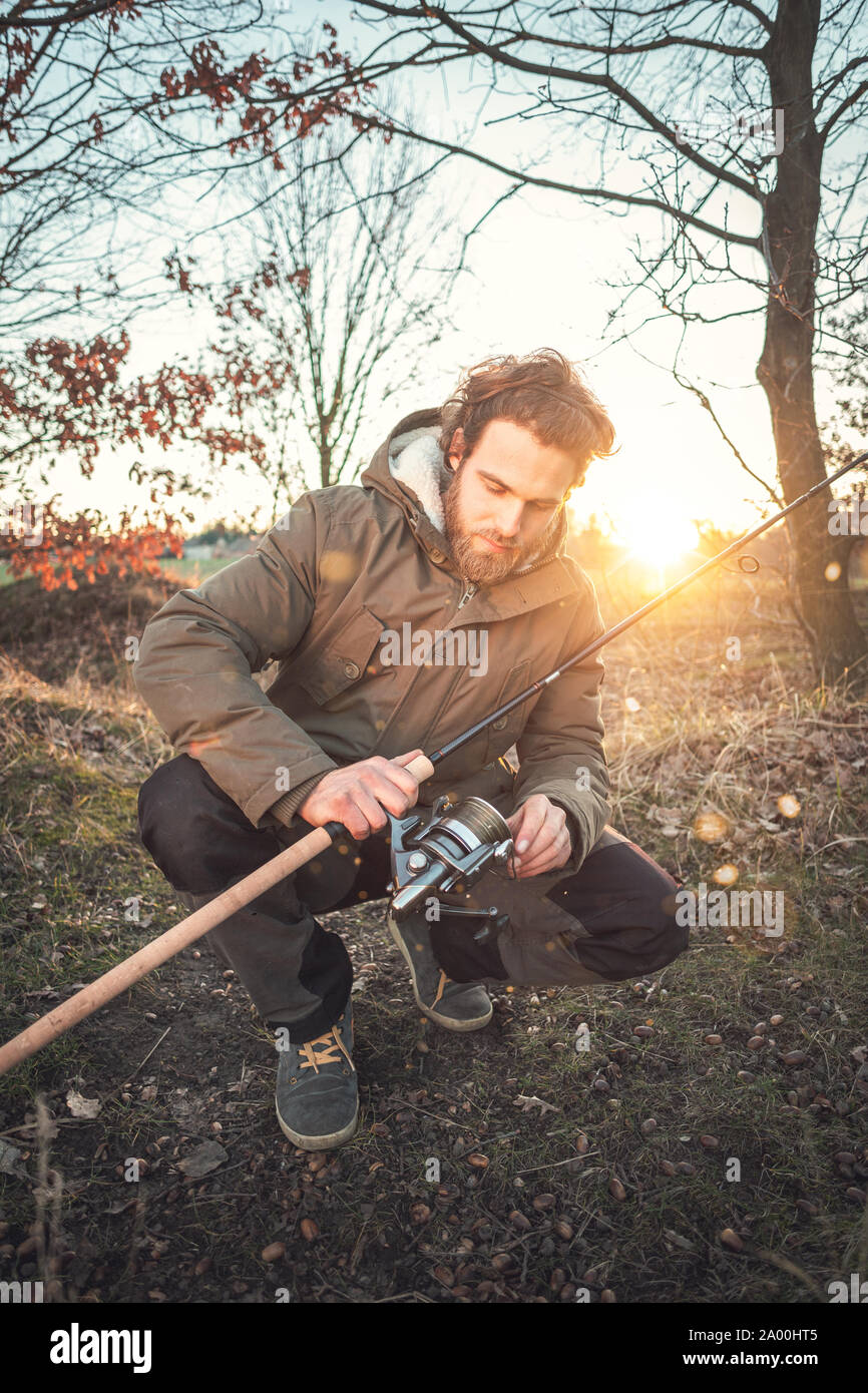 Junger Mann mit einer Angelrute in der Herbstsonne Stockfoto