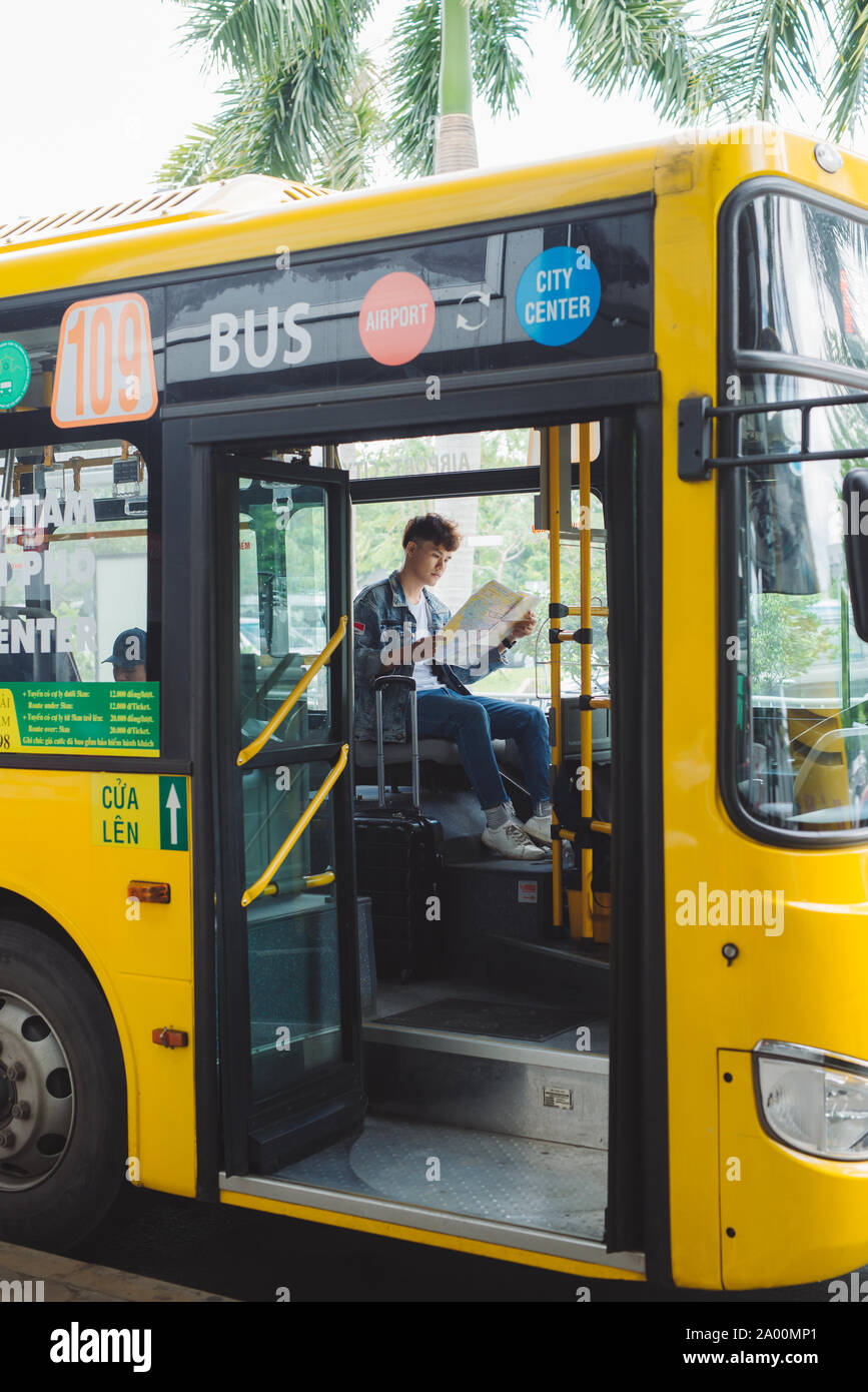 HO CHI MINH CITY, VIETNAM - 22 Juli, 2017: Asiatische männliche Touristen sitzen in Stadtbus und Lesen einer Karte. Stockfoto