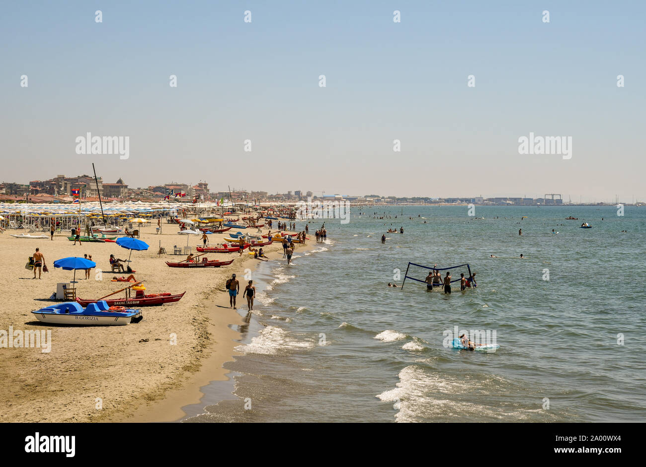 Blick auf den Sandstrand von Lido di Camaiore mit Menschen spielen bei Volley Ball im Meer und im Hintergrund in Viareggio, Toskana, Versilia, Italien Stockfoto