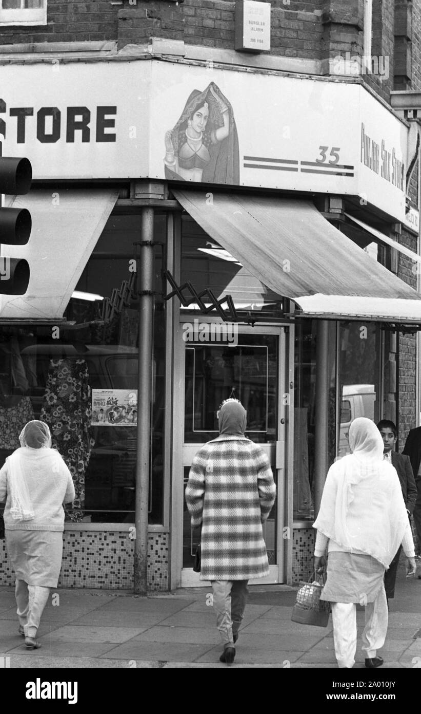 Southall, London 1972. Frauen in der indischen Kleid auf der High Street. Nach Idi Amin bestellt 30.000 Asiaten aus Uganda mit 90 Tagen, die mit britischen Pässen zu England geleitet. Sie wurden gezwungen, ihr Geld, Eigentum und Besitz hinter sich zu lassen. Diese Bilder dokumentieren das Leben für einige der Menschen, wie sie in Southall, westlich von London nieder. Einen Einblick in das Leben vor 47 Jahren für Einwanderer in Großbritannien. Foto von Tony Henshaw Stockfoto