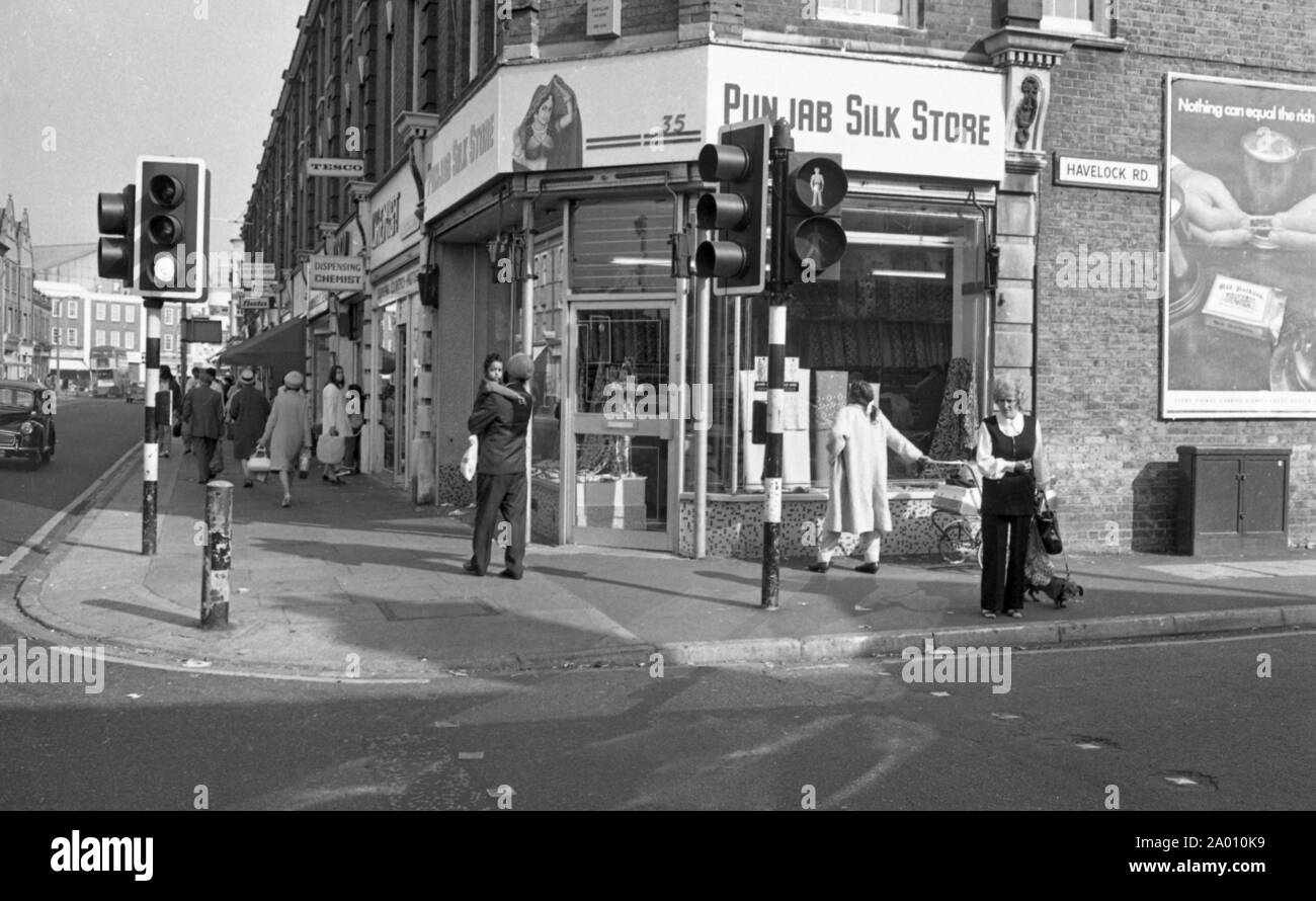 Southall, London 1972. Hohe Straße an der Kreuzung mit der havelock Road, Southall, mit asiatischen Menschen und Geschäfte. Nach Idi Amin bestellt 30.000 Asiaten aus Uganda mit 90 Tagen, die mit britischen Pässen zu England geleitet. Sie wurden gezwungen, ihr Geld, Eigentum und Besitz hinter sich zu lassen. Diese Bilder dokumentieren das Leben für einige der Menschen, wie sie in Southall, westlich von London nieder. Einen Einblick in das Leben vor 47 Jahren für Einwanderer in Großbritannien. Foto von Tony Henshaw Stockfoto